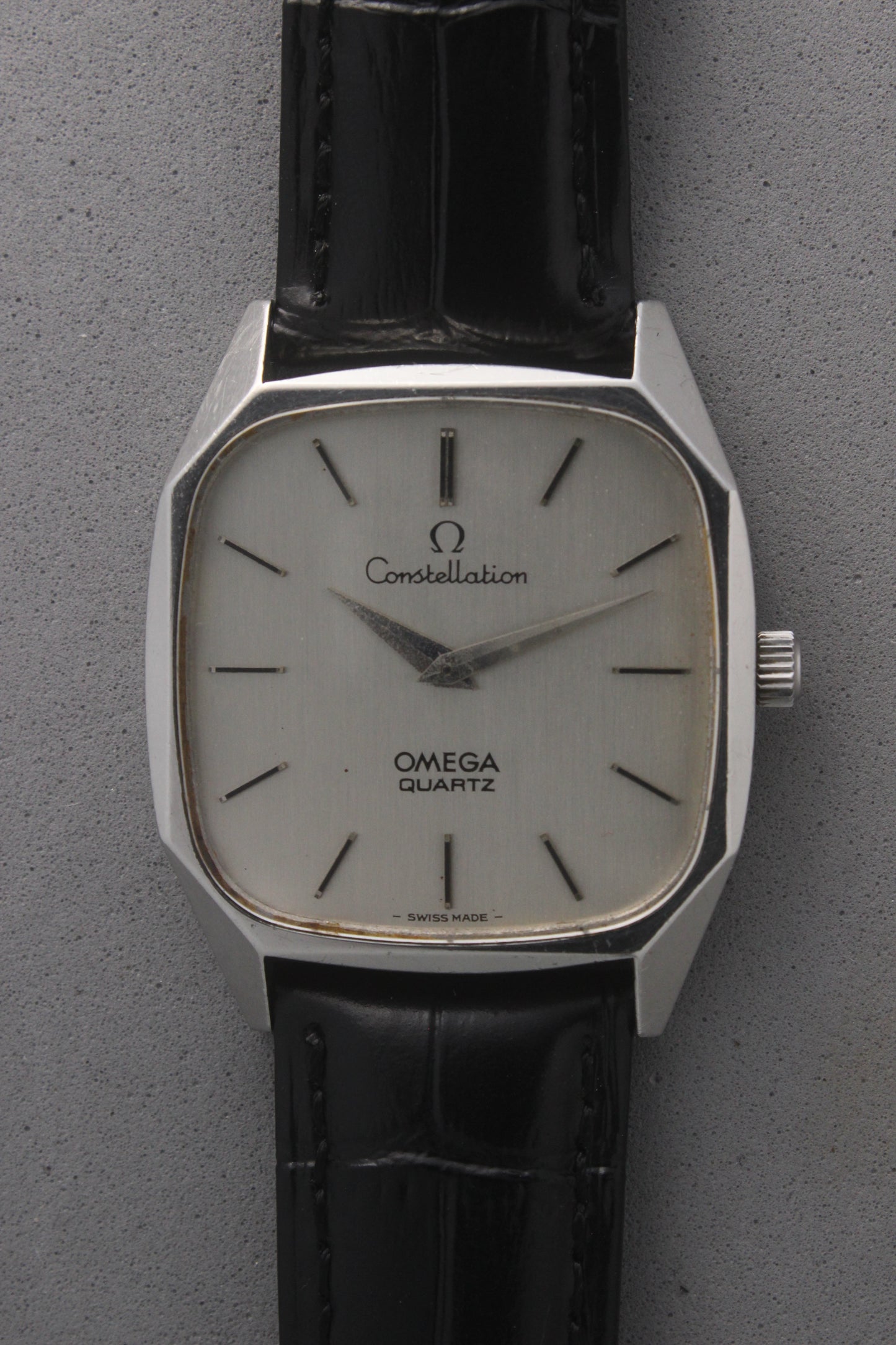Omega Constellation Quartz Ref. 191.0014, featuring a silver-tone dial with black stick indices, slim hands, stainless steel case, and black leather strap.