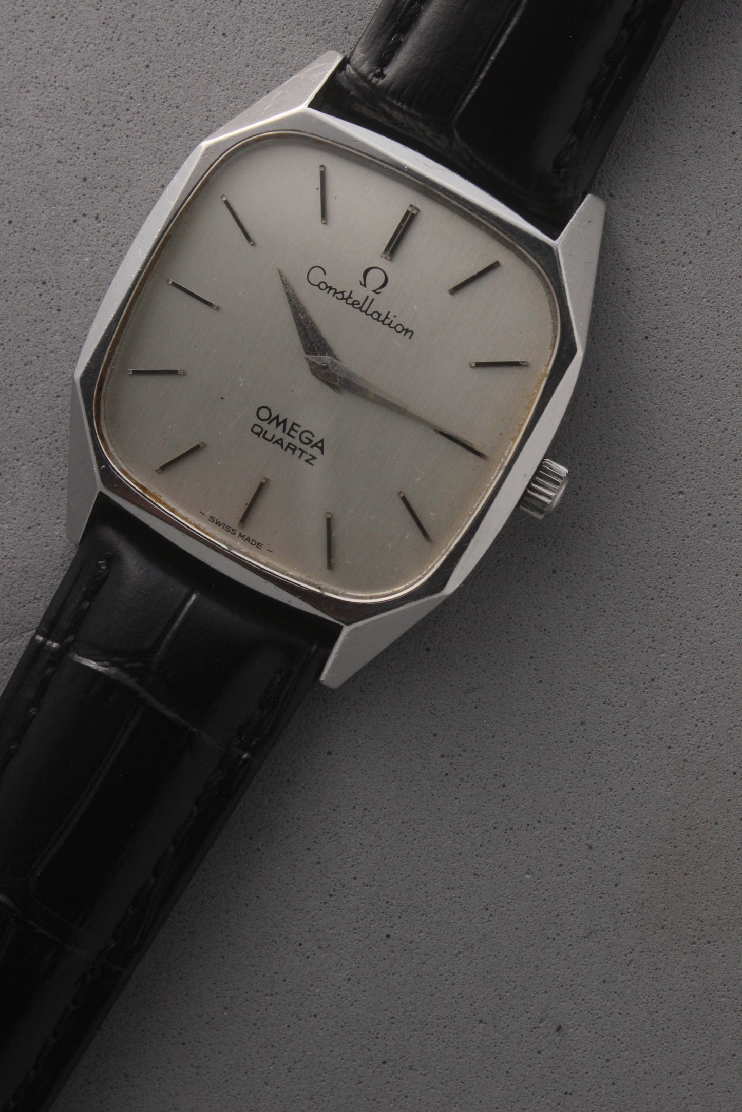 Omega Constellation Quartz Ref. 191.0014, featuring a silver-tone dial with black stick indices, slim hands, stainless steel case, and black leather strap.