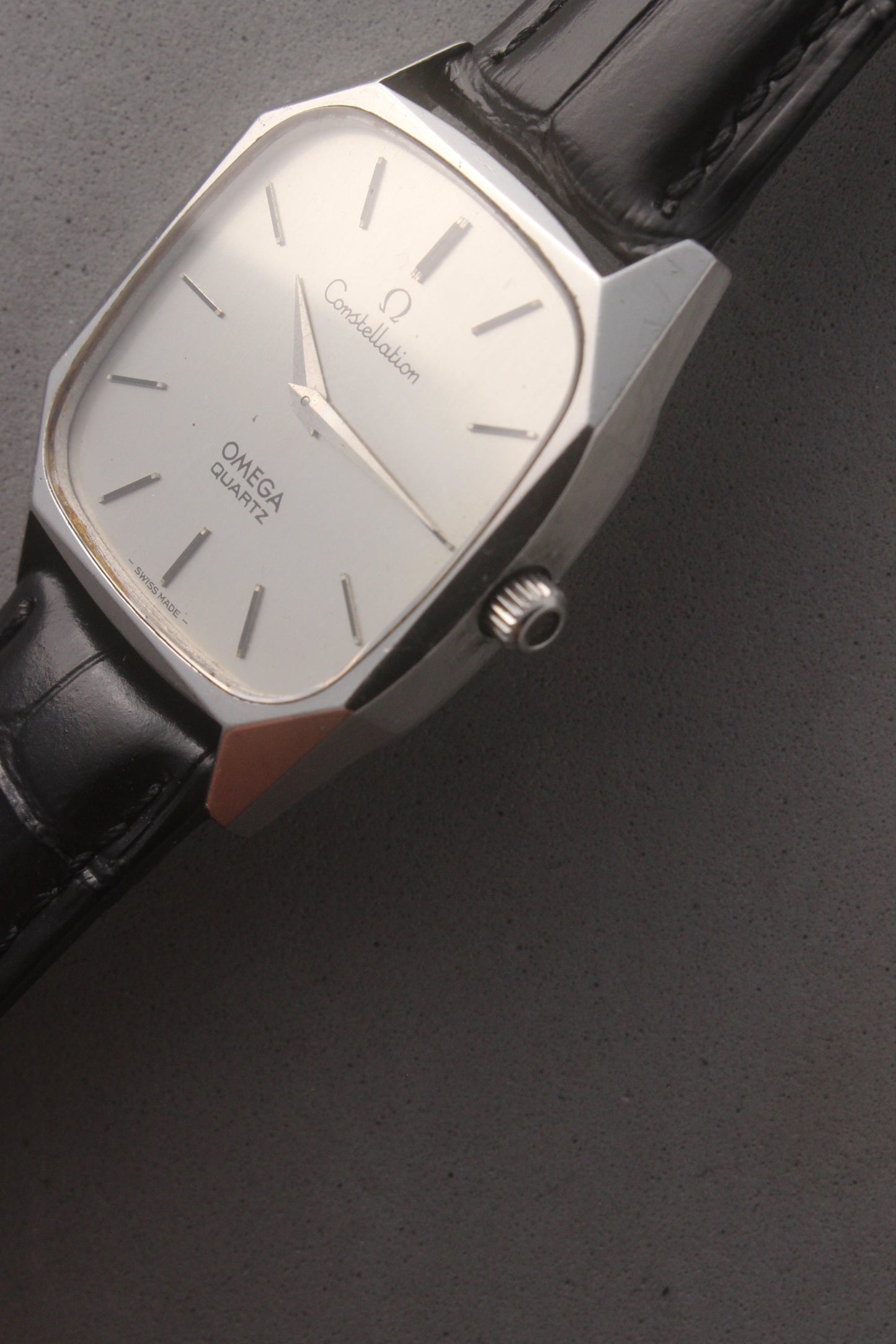 Omega Constellation Quartz Ref. 191.0014, featuring a silver-tone dial with black stick indices, slim hands, stainless steel case, and black leather strap.