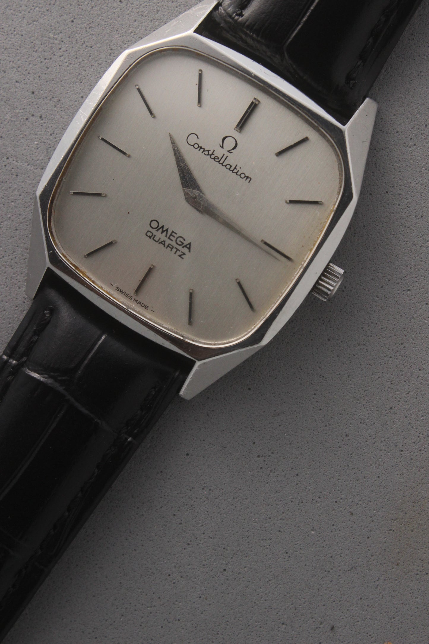 Omega Constellation Quartz Ref. 191.0014, featuring a silver-tone dial with black stick indices, slim hands, stainless steel case, and black leather strap.