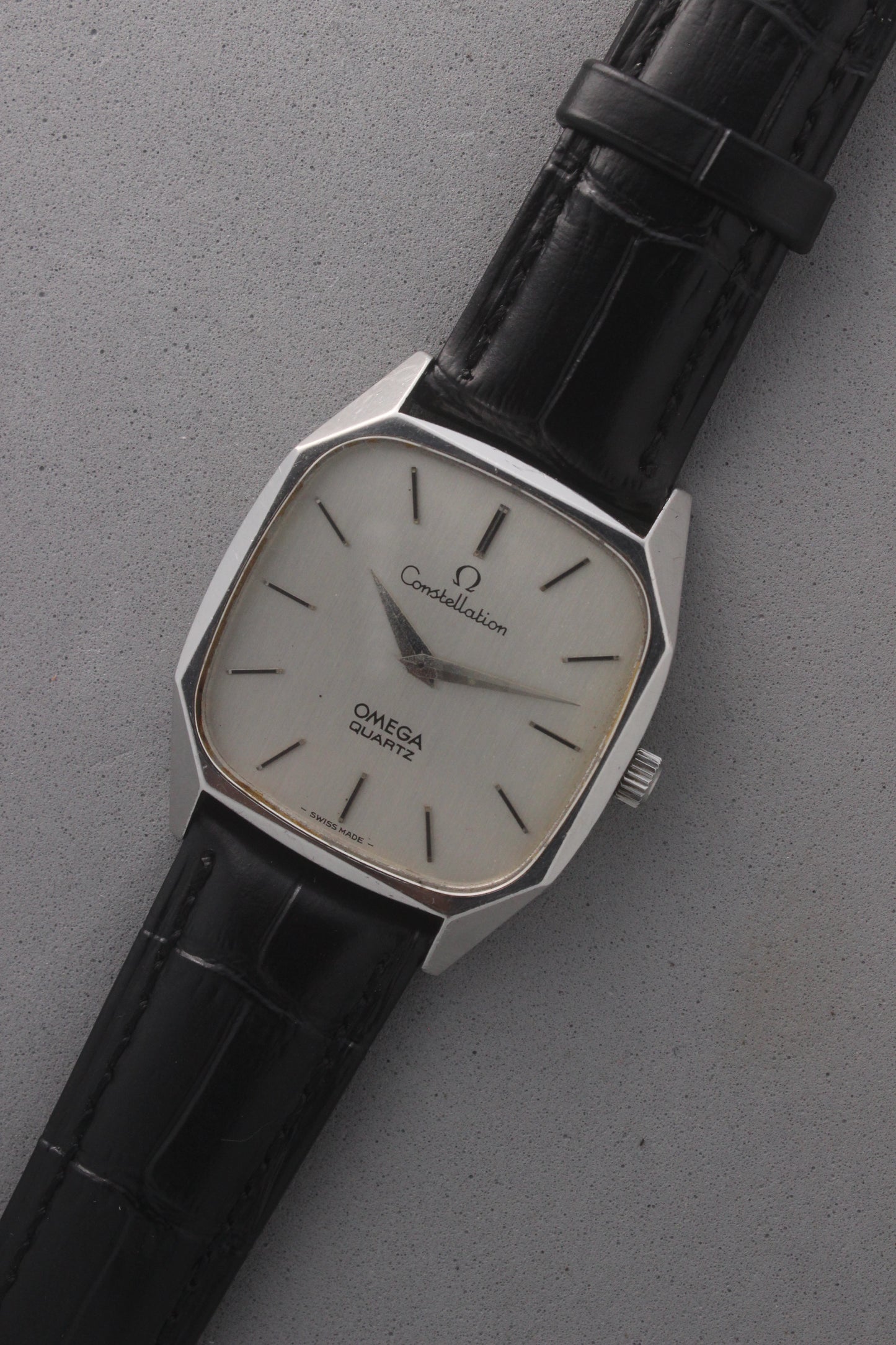 Omega Constellation Quartz Ref. 191.0014, featuring a silver-tone dial with black stick indices, slim hands, stainless steel case, and black leather strap.