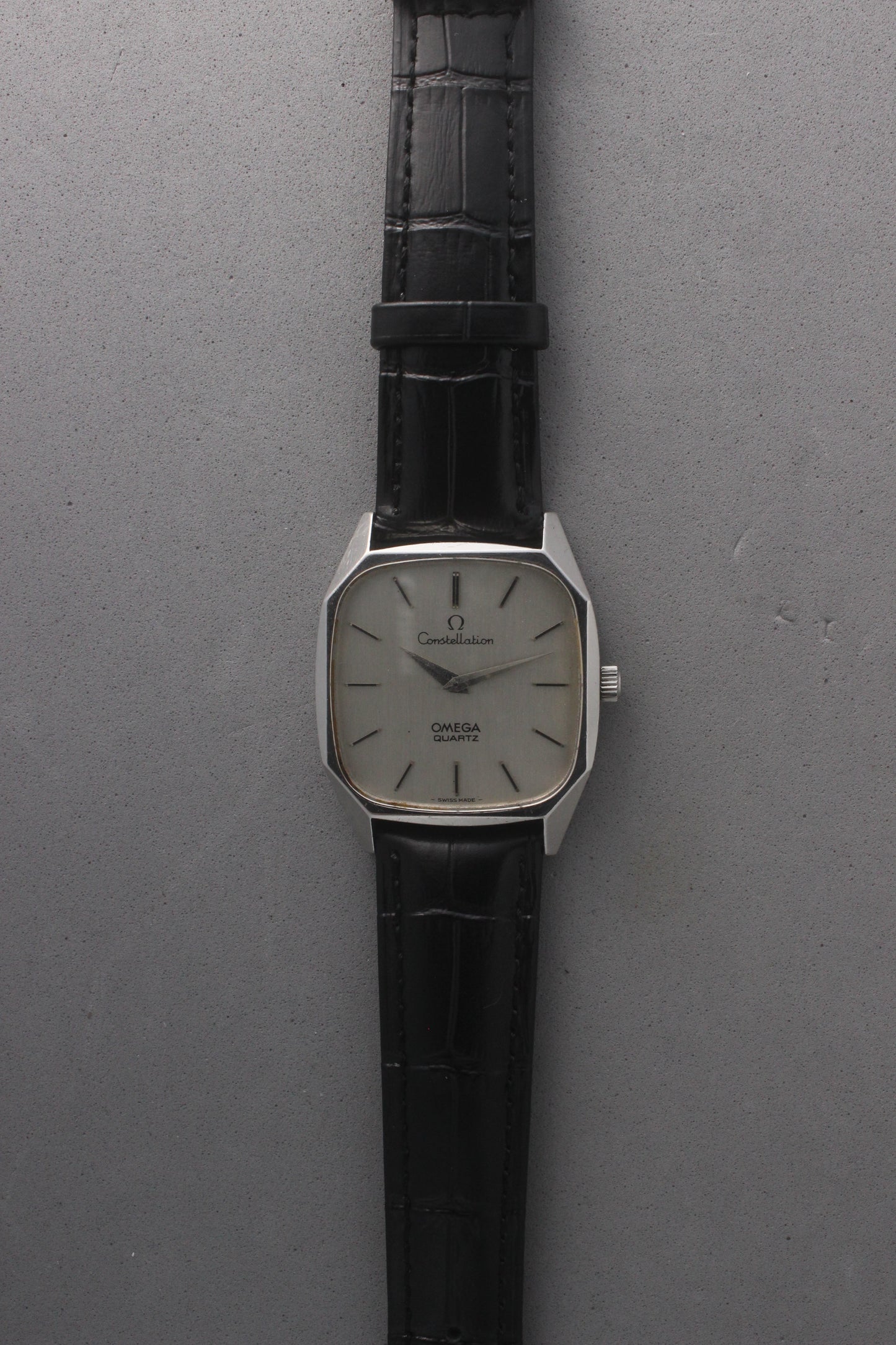 Omega Constellation Quartz Ref. 191.0014, featuring a silver-tone dial with black stick indices, slim hands, stainless steel case, and black leather strap.