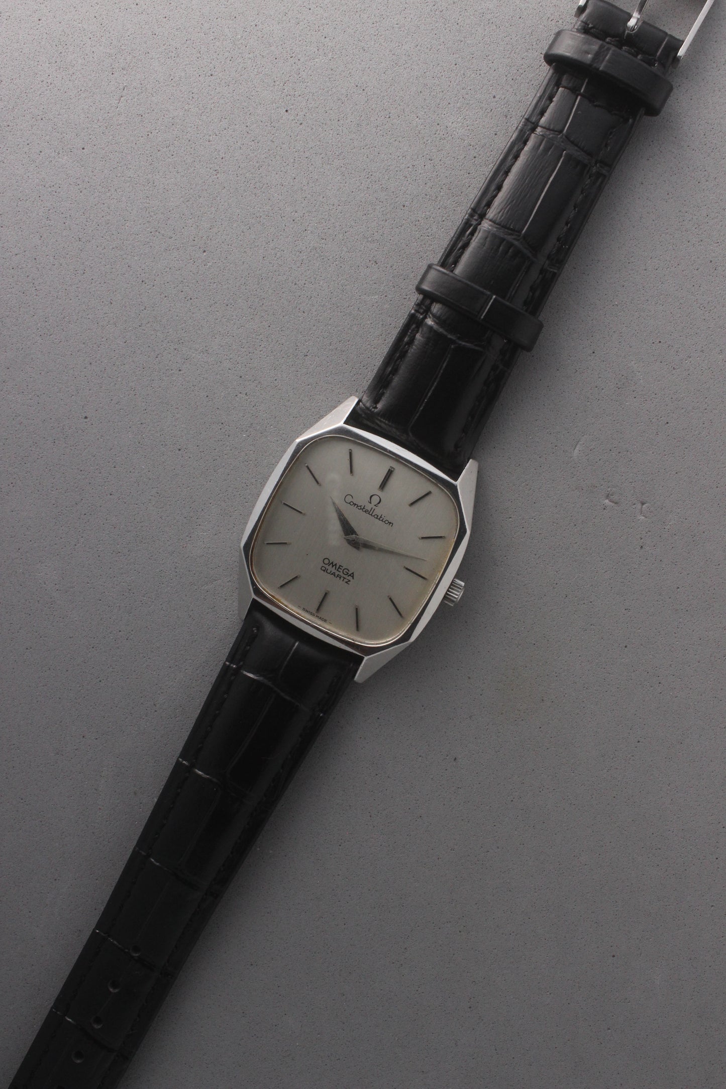 Omega Constellation Quartz Ref. 191.0014, featuring a silver-tone dial with black stick indices, slim hands, stainless steel case, and black leather strap.