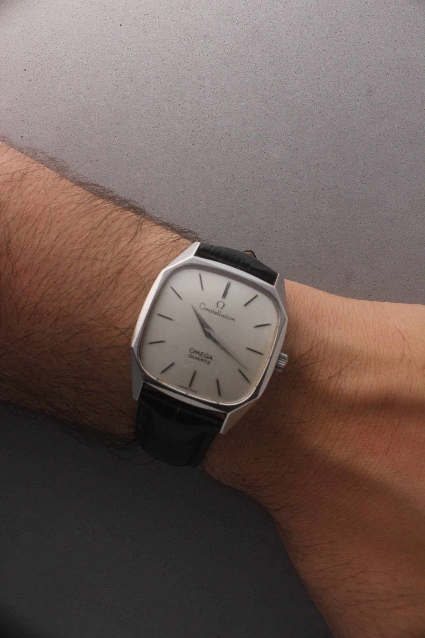 Omega Constellation Quartz Ref. 191.0014, featuring a silver-tone dial with black stick indices, slim hands, stainless steel case, and black leather strap.