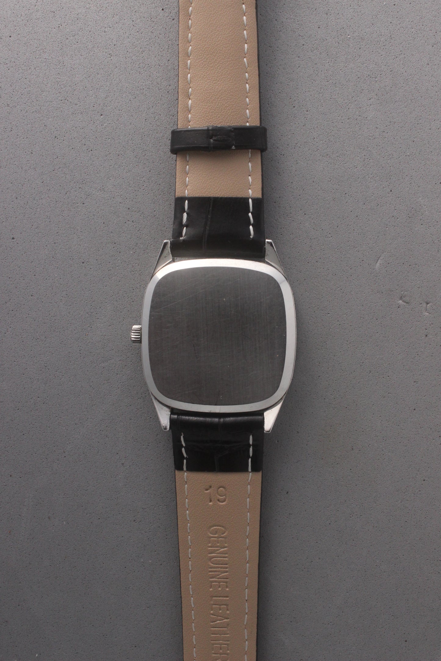 Back view of Omega Quartz Ref. 191.0014, showcasing a stainless steel case back, paired with a genuine leather strap featuring white stitching and size marking.