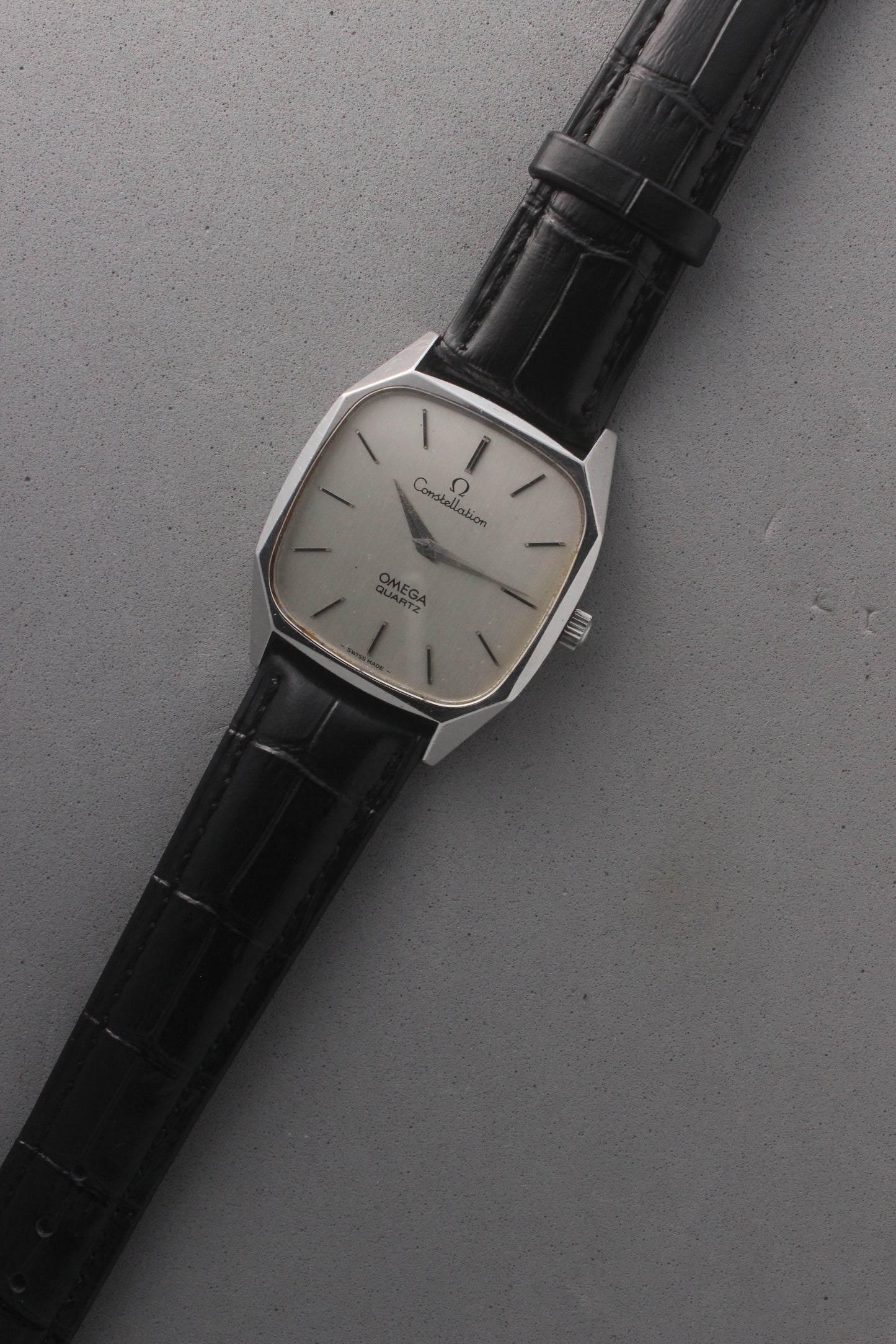 Omega Constellation Quartz Ref. 191.0014, featuring a silver-tone dial with black stick indices, slim hands, stainless steel case, and black leather strap.