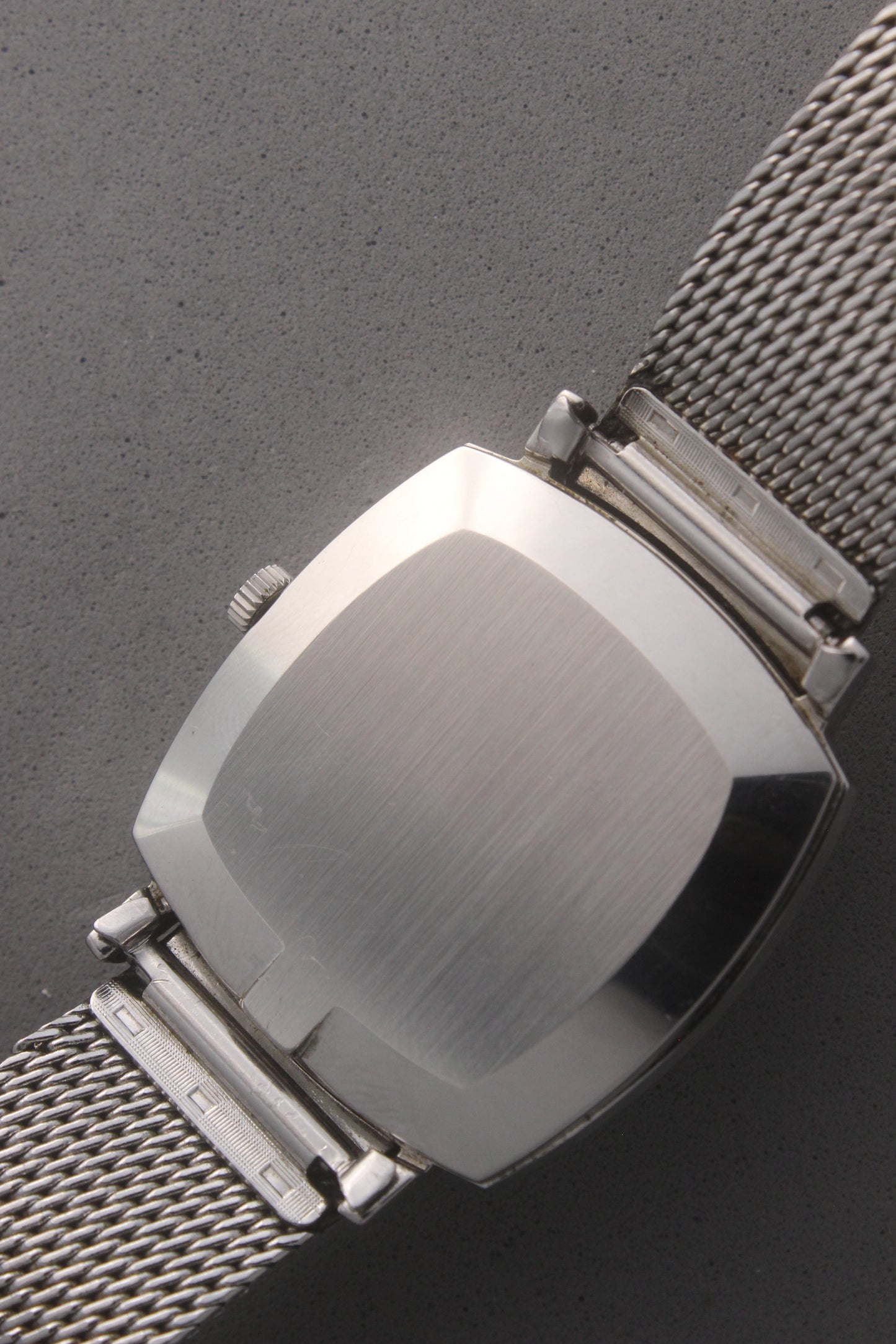 Rear view of the Omega Genève watch, reference number 132.0052, displaying the polished stainless steel case back and seamless integration with the mesh bracelet. Emphasizes the watch’s refined craftsmanship and timeless design for vintage collectors and enthusiasts.