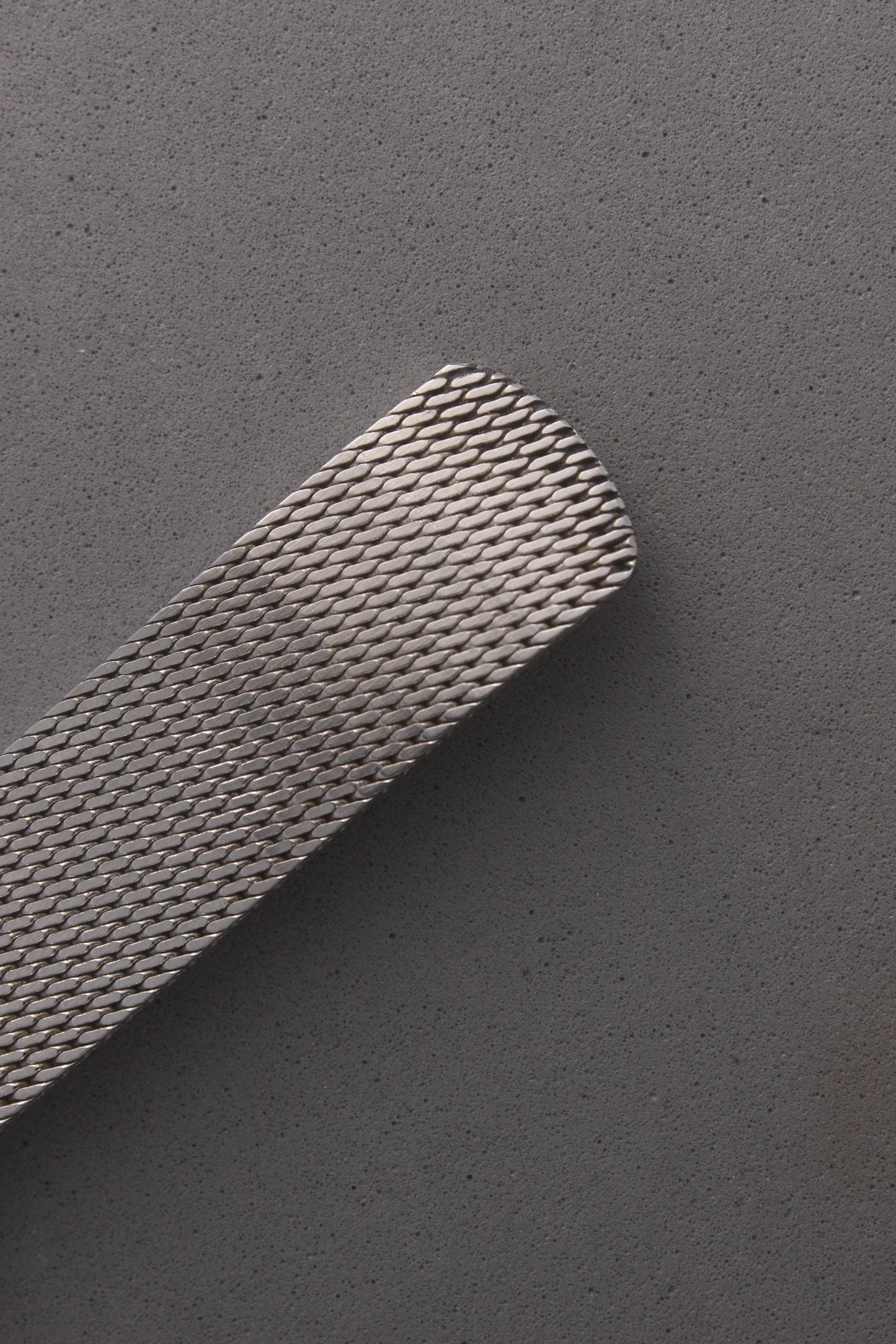 Close-up view of the stainless steel mesh bracelet from the Omega Genève watch, reference number 132.0052, showcasing its intricate woven design and elegant craftsmanship. Ideal for collectors seeking timeless sophistication and durability.