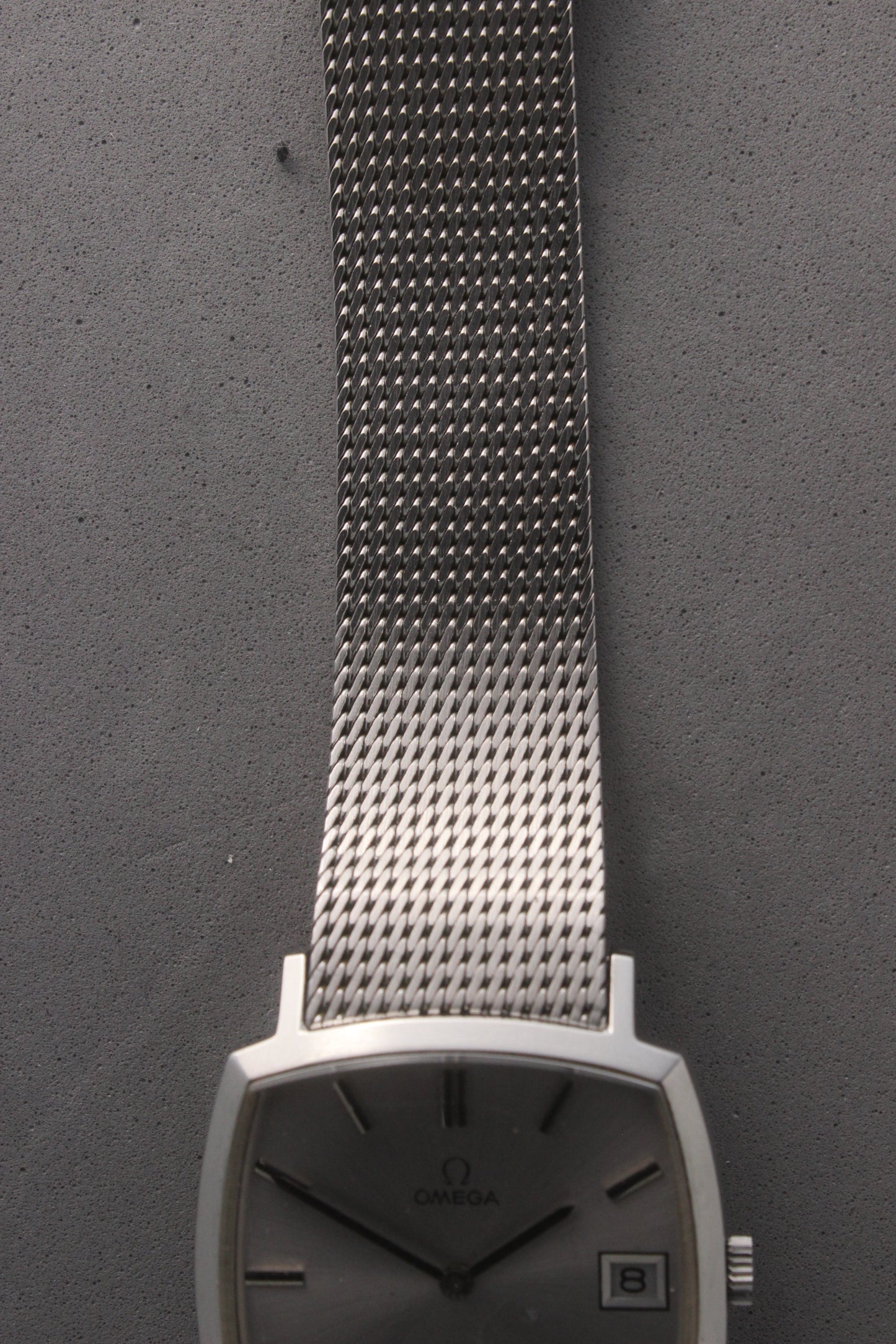 Close-up view of the stainless steel mesh bracelet from the Omega Genève watch, reference number 132.0052, showcasing its intricate woven design and elegant craftsmanship. Ideal for collectors seeking timeless sophistication and durability.