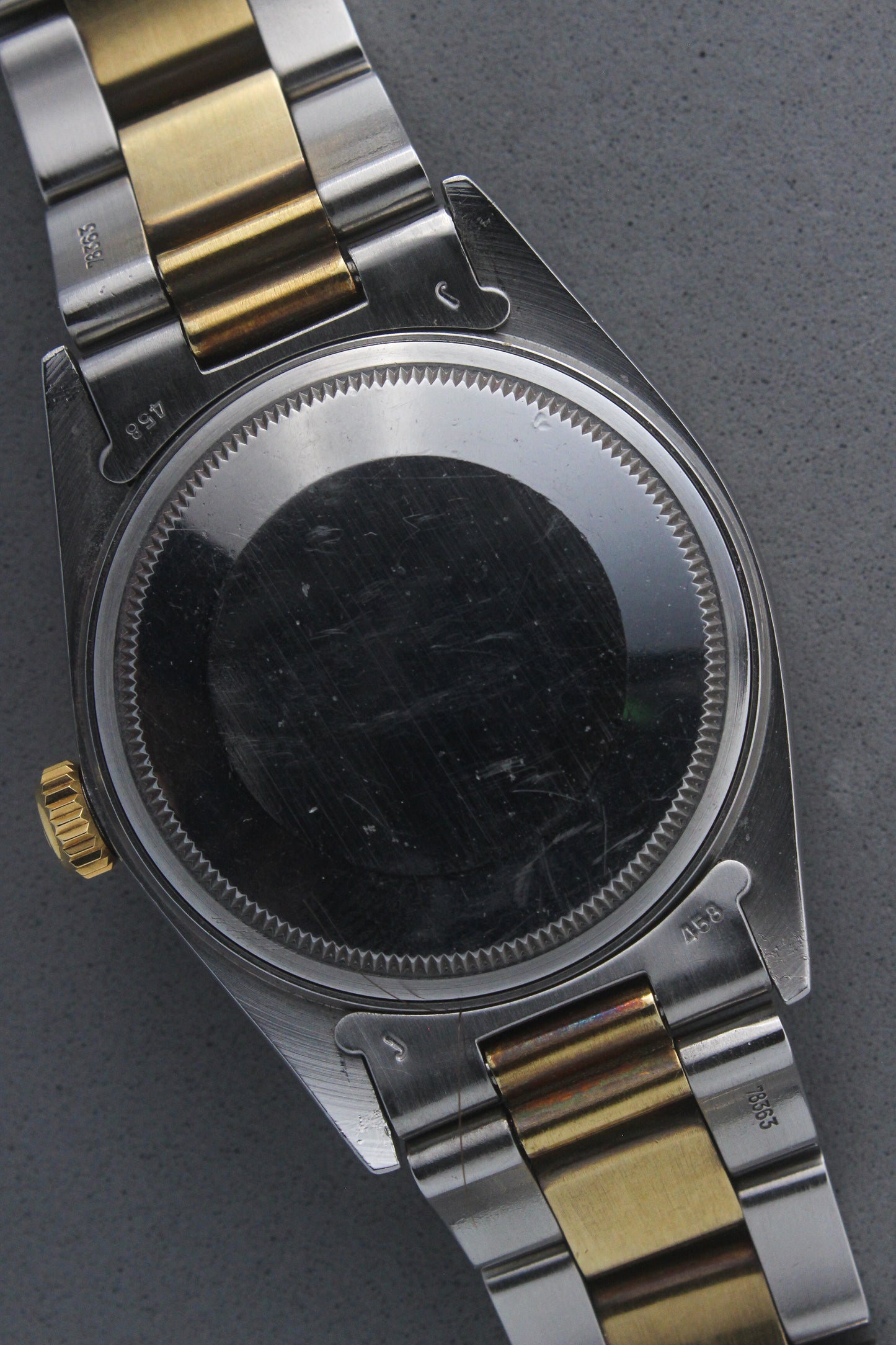 Rear view of the Rolex Datejust reference number 16013, highlighting the stainless steel case back, which is blank and polished, along with the two-tone stainless steel and yellow gold Jubilee bracelet. This image showcases the robust craftsmanship and intricate detailing of the watch, including the solid end links and clasp markings.