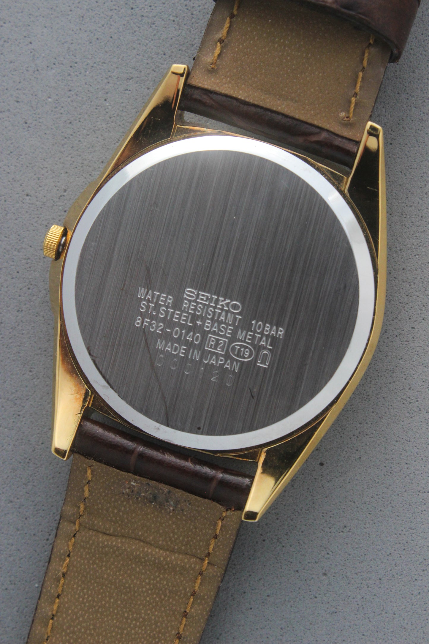The stainless steel case back of the Seiko Caster 8F32-0140 showcases clear engravings including "Water Resistant 10
Bar" and "Made in Japan." Highlighting its robust craftsmanship, the model reference number 8F32-0140 is prominently displayed.