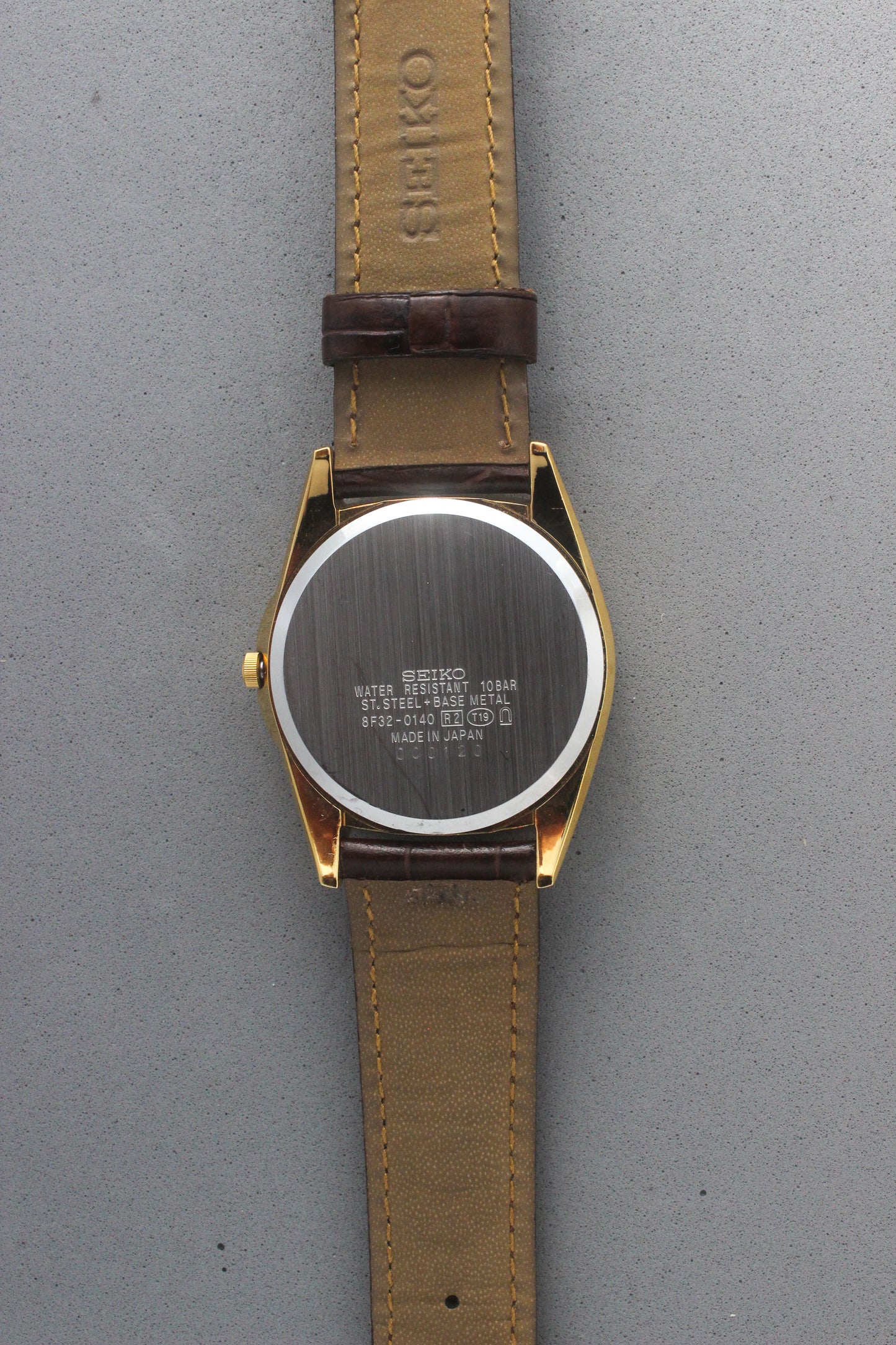 The stainless steel case back of the Seiko Caster 8F32-0140 showcases clear engravings including "Water Resistant 10
Bar" and "Made in Japan." Highlighting its robust craftsmanship, the model reference number 8F32-0140 is prominently displayed.