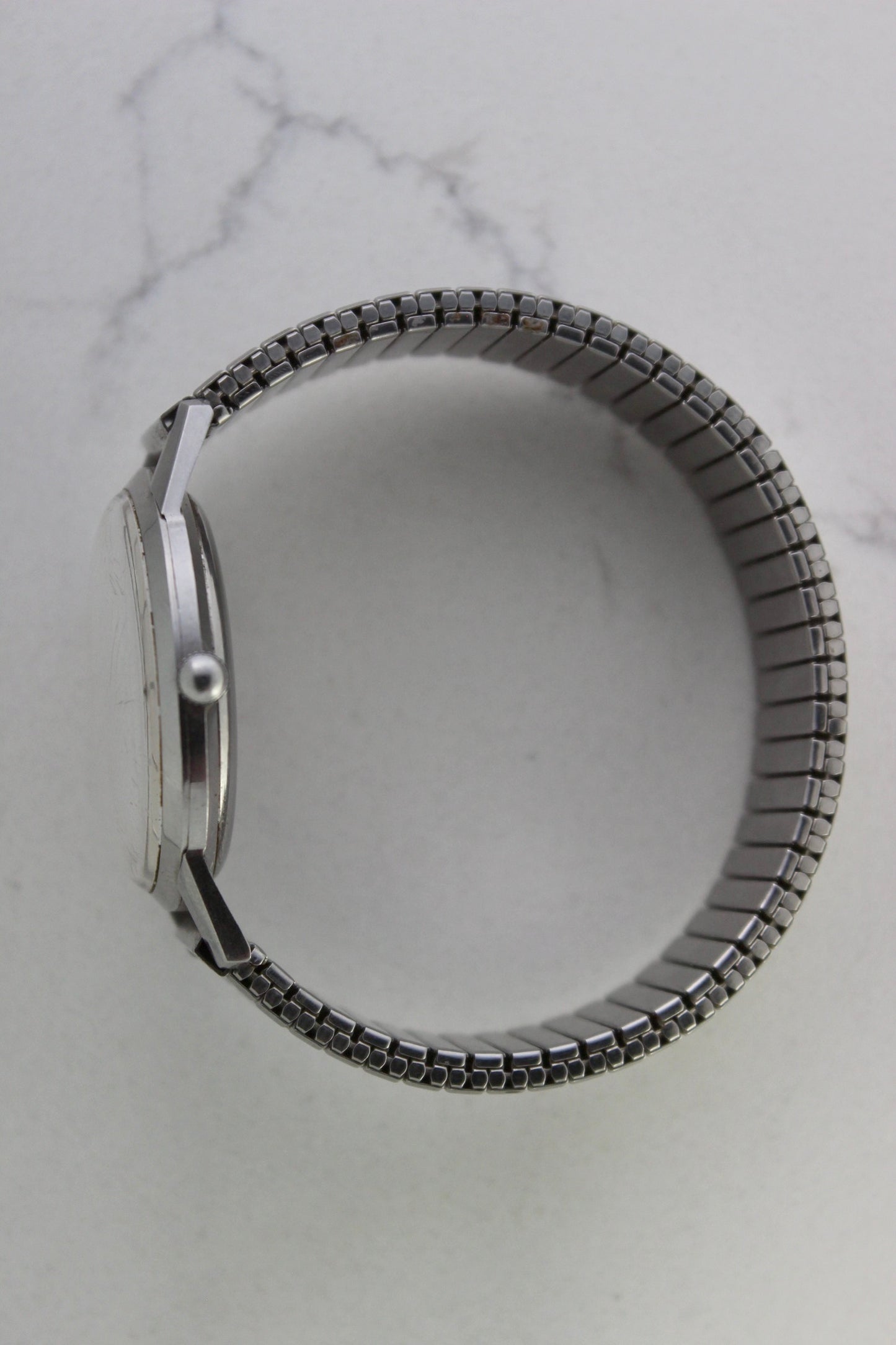 Vintage Seiko Crown 35.5mm stainless steel manual-wind watch from July 1960. Features a flat satin silver lacquered dial with silver indices, a double logo at the 12 and 6 o’clock positions, and slim silver stick hands for hours, minutes, and seconds. The ultra-slim 10mm case is complemented by a stainless steel fixed bezel and a vintage-style stretch bracelet with brushed and polished surfaces. In great condition with minimal signs of wear on the bracelet and crystal. A rare collector's piece.