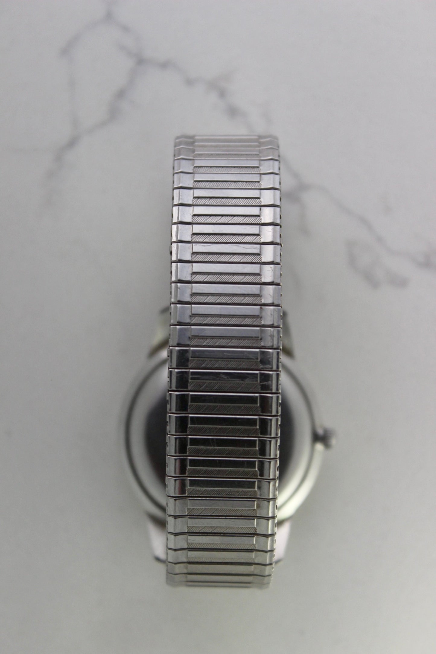 Vintage Seiko Crown 35.5mm stainless steel manual-wind watch from July 1960. Features a flat satin silver lacquered dial with silver indices, a double logo at the 12 and 6 o’clock positions, and slim silver stick hands for hours, minutes, and seconds. The ultra-slim 10mm case is complemented by a stainless steel fixed bezel and a vintage-style stretch bracelet with brushed and polished surfaces. In great condition with minimal signs of wear on the bracelet and crystal. A rare collector's piece.