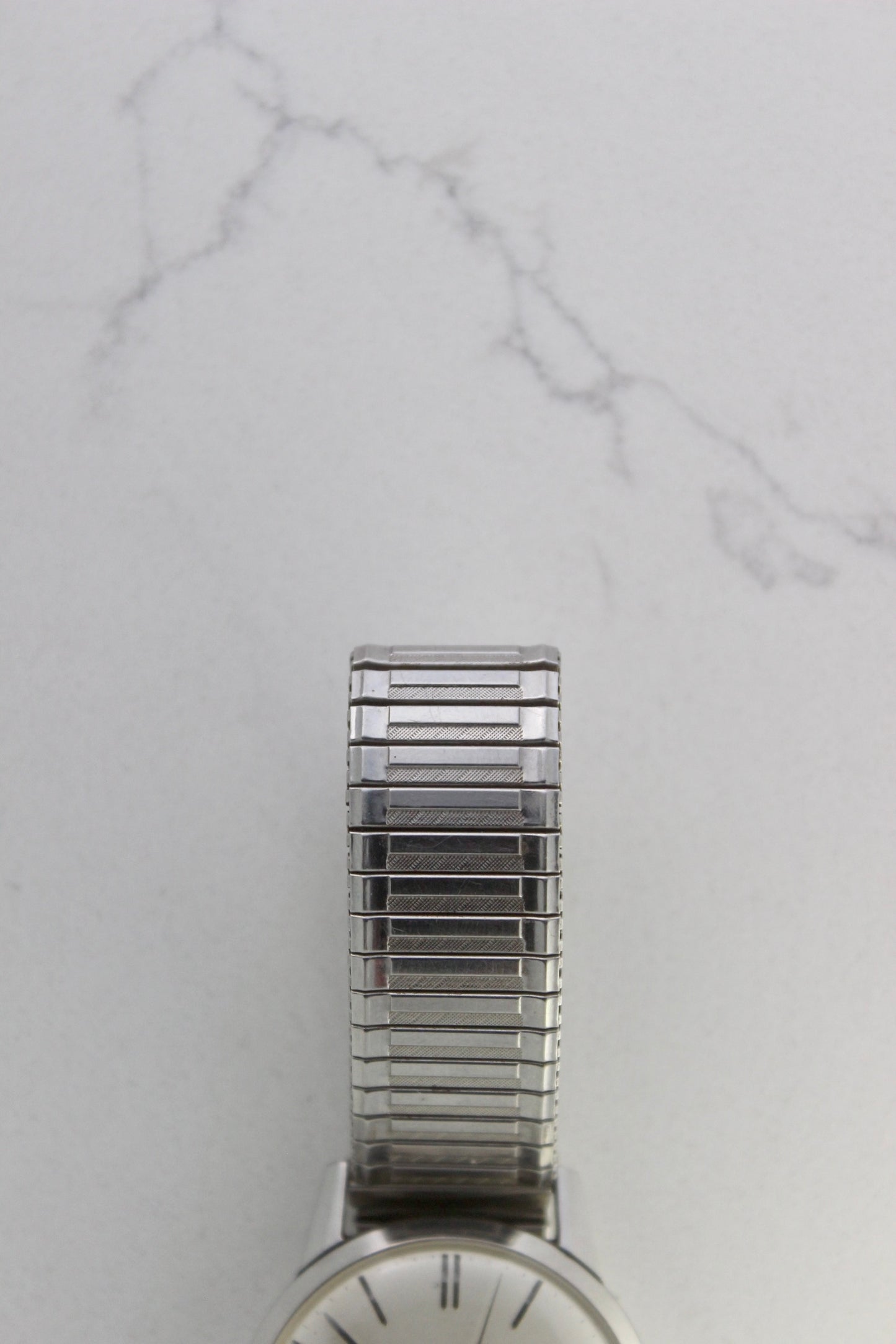 Vintage Seiko Crown 35.5mm stainless steel manual-wind watch from July 1960. Features a flat satin silver lacquered dial with silver indices, a double logo at the 12 and 6 o’clock positions, and slim silver stick hands for hours, minutes, and seconds. The ultra-slim 10mm case is complemented by a stainless steel fixed bezel and a vintage-style stretch bracelet with brushed and polished surfaces. In great condition with minimal signs of wear on the bracelet and crystal. A rare collector's piece.