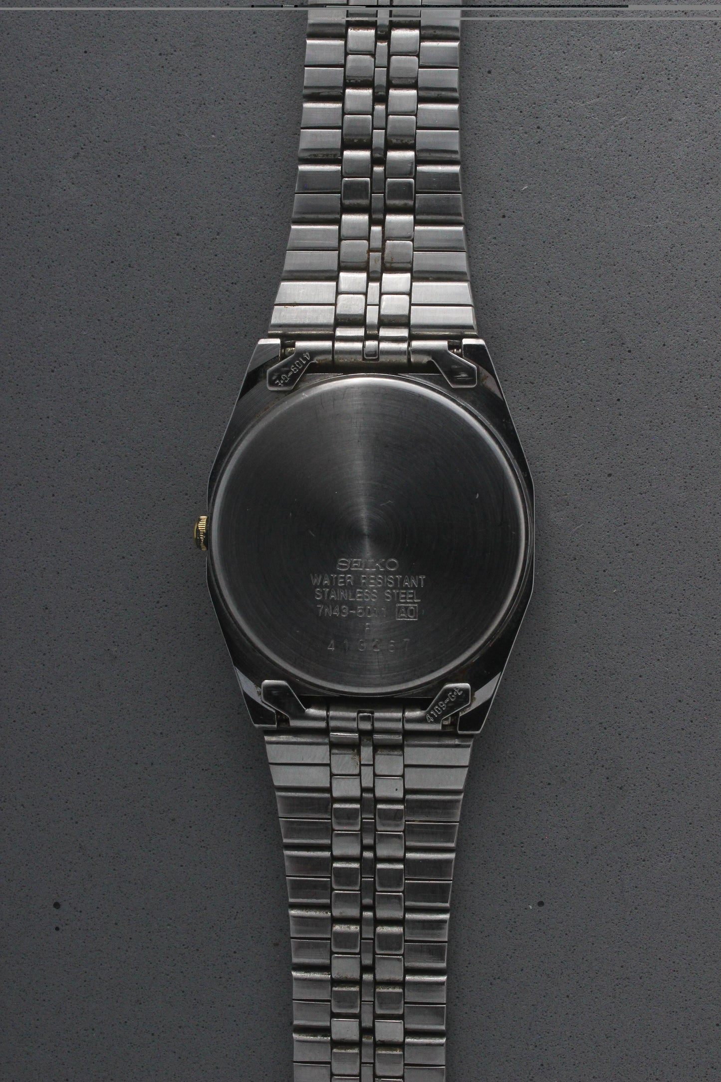 A close-up of the stainless steel case back for the Seiko Quartz 7N43-5011, engraved with model details including "7N43-5011,"
"Water Resistant," and "Made in Japan." The brushed finish highlights the craftsmanship and quality.