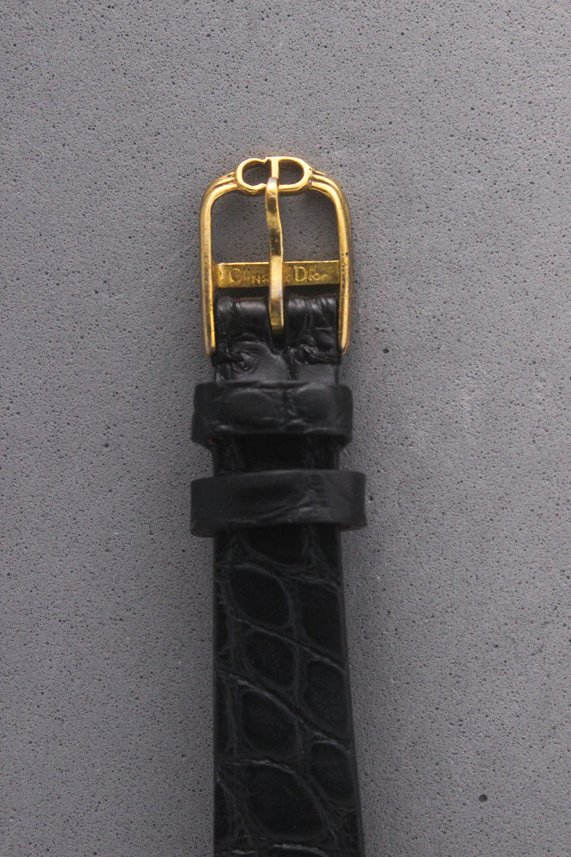 Close-up of the Christian Dior Paris vintage watch’s black alligator leather strap with a gold-tone buckle engraved with the ‘Christian Dior’ logo. A luxurious finishing touch that enhances the elegance and sophistication of this timeless timepiece, ref. 900-11.