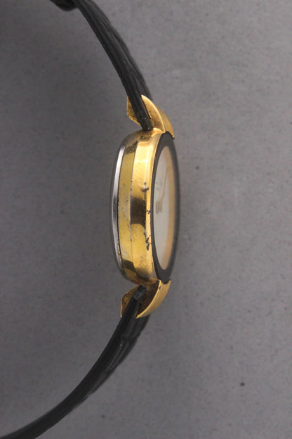 Elegant Christian Dior Paris vintage watch featuring a minimalist gold-plated round case, black enamel bezel, sleek black alligator leather strap, and classic white dial with gold-tone hands. A luxurious and timeless accessory for discerning collectors and fashion enthusiasts. ref. 900-11