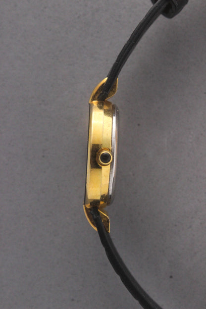 Elegant Christian Dior Paris vintage watch featuring a minimalist gold-plated round case, black enamel bezel, sleek black alligator leather strap, and classic white dial with gold-tone hands. A luxurious and timeless accessory for discerning collectors and fashion enthusiasts. ref. 900-11