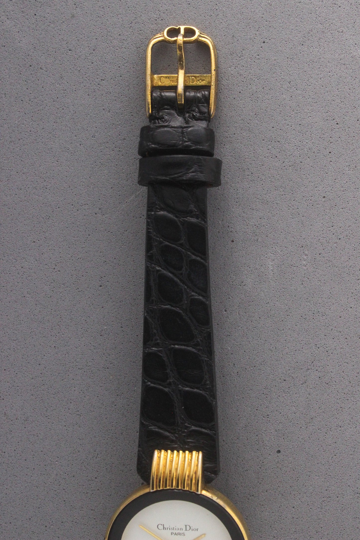 Close-up of the Christian Dior Paris vintage watch’s black alligator leather strap with a gold-tone buckle engraved with the ‘Christian Dior’ logo. A luxurious finishing touch that enhances the elegance and sophistication of this timeless timepiece, ref. 900-11.
