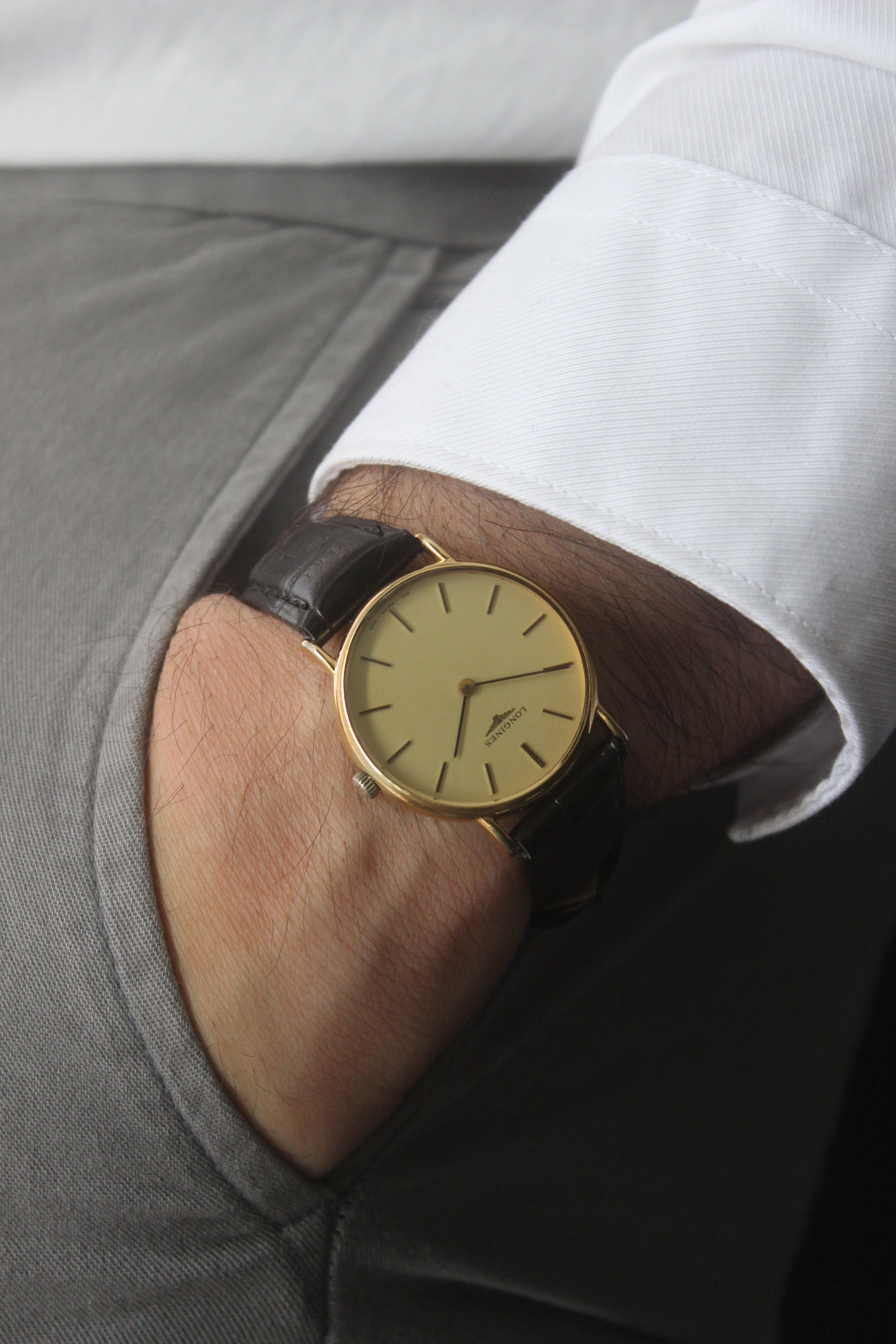 Longines gold gents dress watch, Ref. 1207.832, featuring a minimalist yellow dial, black hour markers, slim black hands, gold-plated case, and black leather strap.