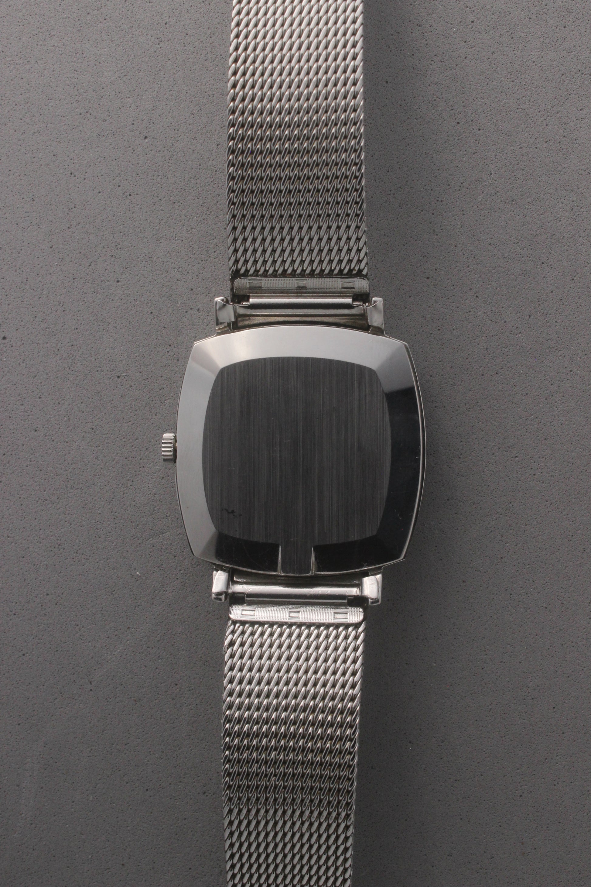 Rear view of the Omega Genève watch, reference number 132.0052, displaying the polished stainless steel case back and seamless integration with the mesh bracelet. Emphasizes the watch’s refined craftsmanship and timeless design for vintage collectors and enthusiasts.