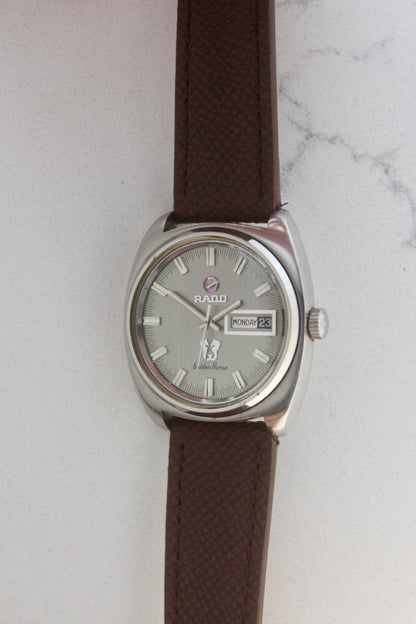 Vintage Rado Golden Horse watch, reference number 11816, featuring brown strap, silver-tone dial with baton hour markers, day-date display at 3 o’clock, and the signature Golden Horse logo. A timeless and elegant collector’s timepiece from Rado.