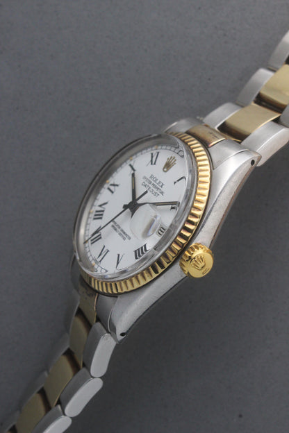 Rolex Datejust reference number 16013, featuring a two-tone stainless steel and yellow gold Jubilee bracelet, a fluted yellow gold bezel, and a classic white dial with black Roman numeral hour markers. The watch includes a date window at 3 o’clock, magnified by a Cyclops lens, and the ‘Rolex Oyster Perpetual Datejust’ text on the dial, showcasing its timeless and elegant design.