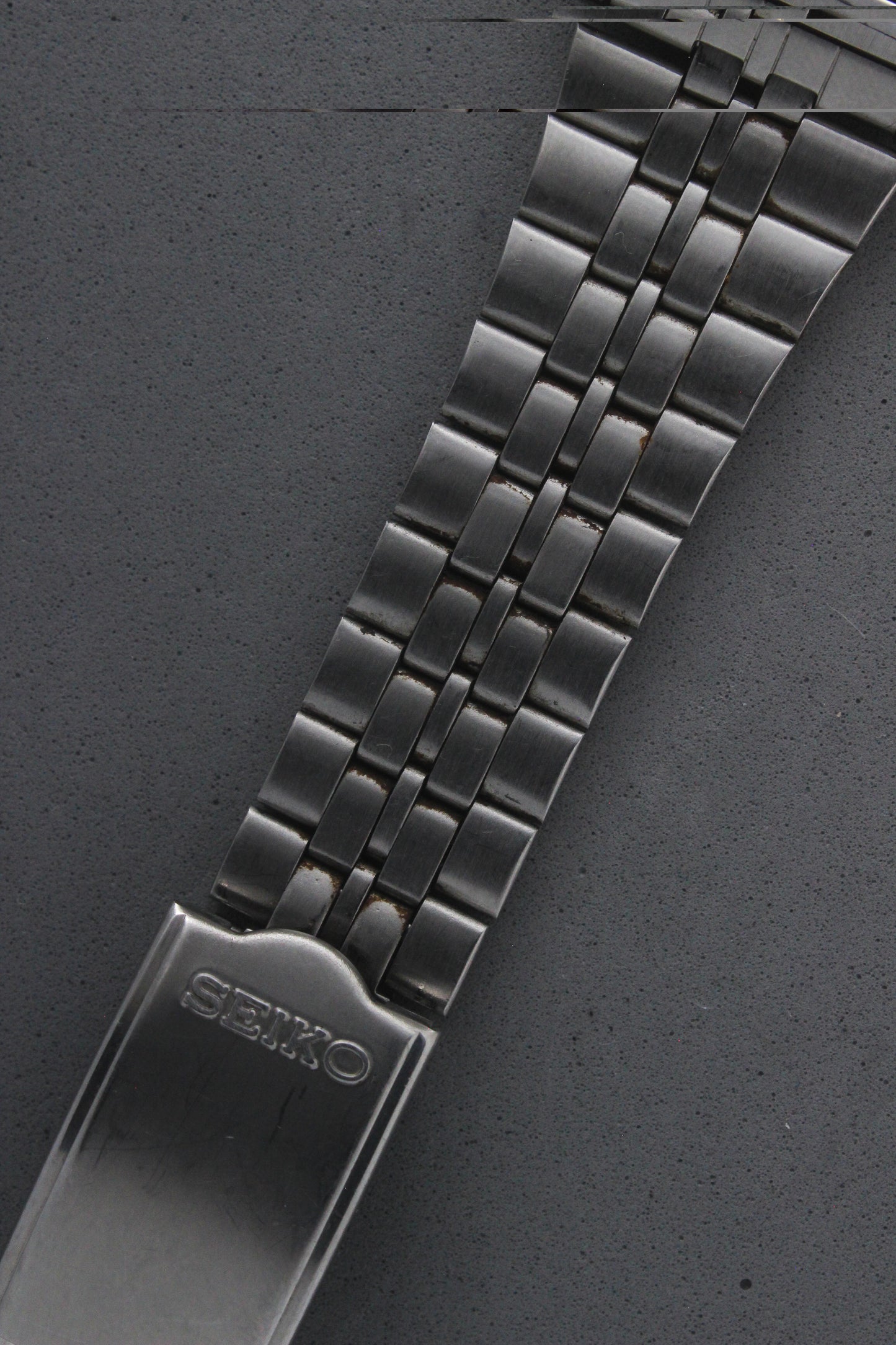 Detailed view of the Seiko 7N43-5011's stainless steel bracelet, showcasing its polished finish and engraved "Seiko" logo on the clasp. The bracelet enhances the watch's durability and elegance.