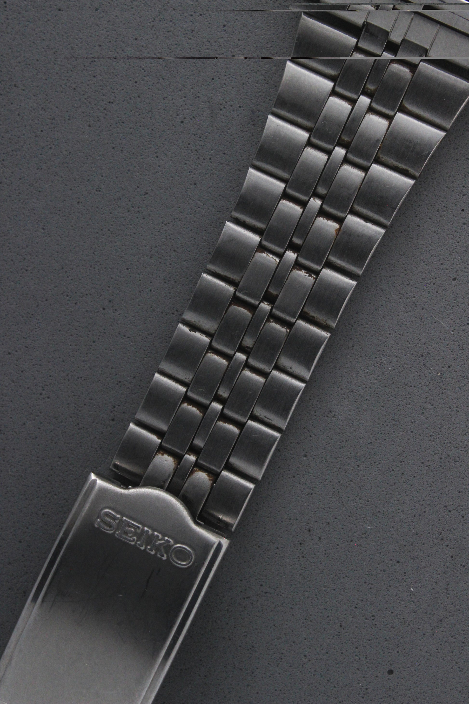 Detailed view of the Seiko 7N43-5011's stainless steel bracelet, showcasing its polished finish and engraved "Seiko" logo on the clasp. The bracelet enhances the watch's durability and elegance.