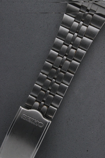 Detailed view of the Seiko 7N43-5011's stainless steel bracelet, showcasing its polished finish and engraved "Seiko" logo on the clasp. The bracelet enhances the watch's durability and elegance.