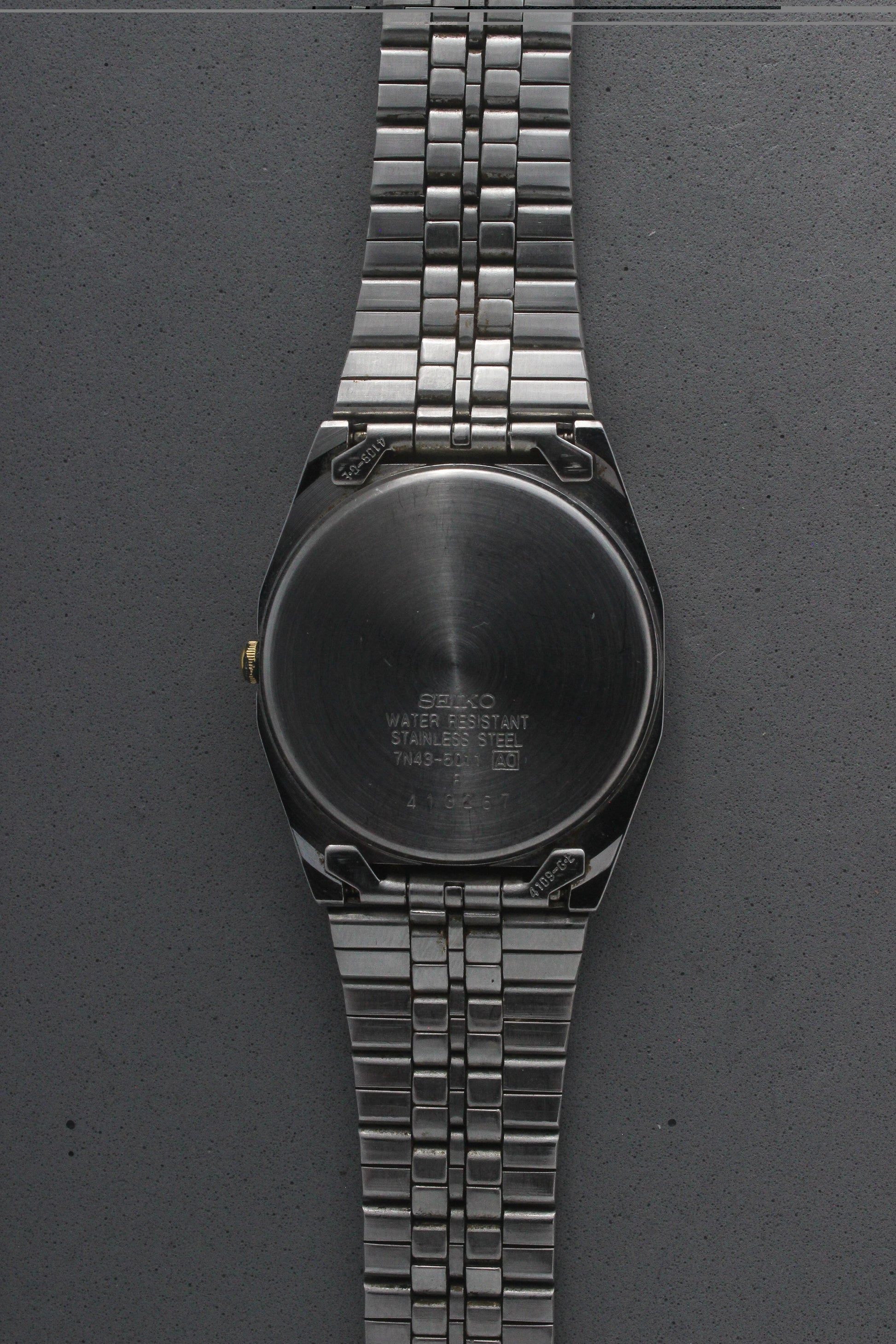 A close-up of the stainless steel case back for the Seiko Quartz 7N43-5011, engraved with model details including "7N43-5011,"
"Water Resistant," and "Made in Japan." The brushed finish highlights the craftsmanship and quality.