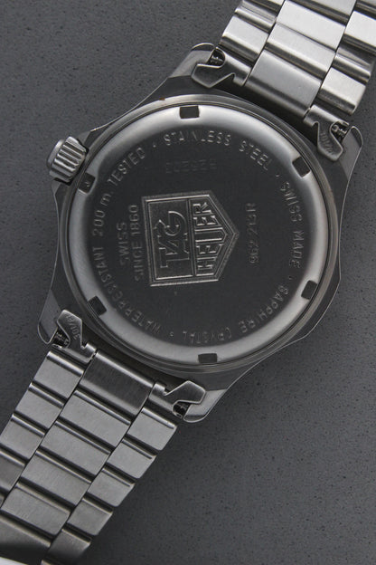 Close-up of the TAG Heuer Professional Ref.
962.213R case back showcasing engravings including "962.213R," "Water Resistant 200m
Tested," and "Swiss Made." The TAG Heuer logo and brushed stainless steel highlight the quality craftsmanship.