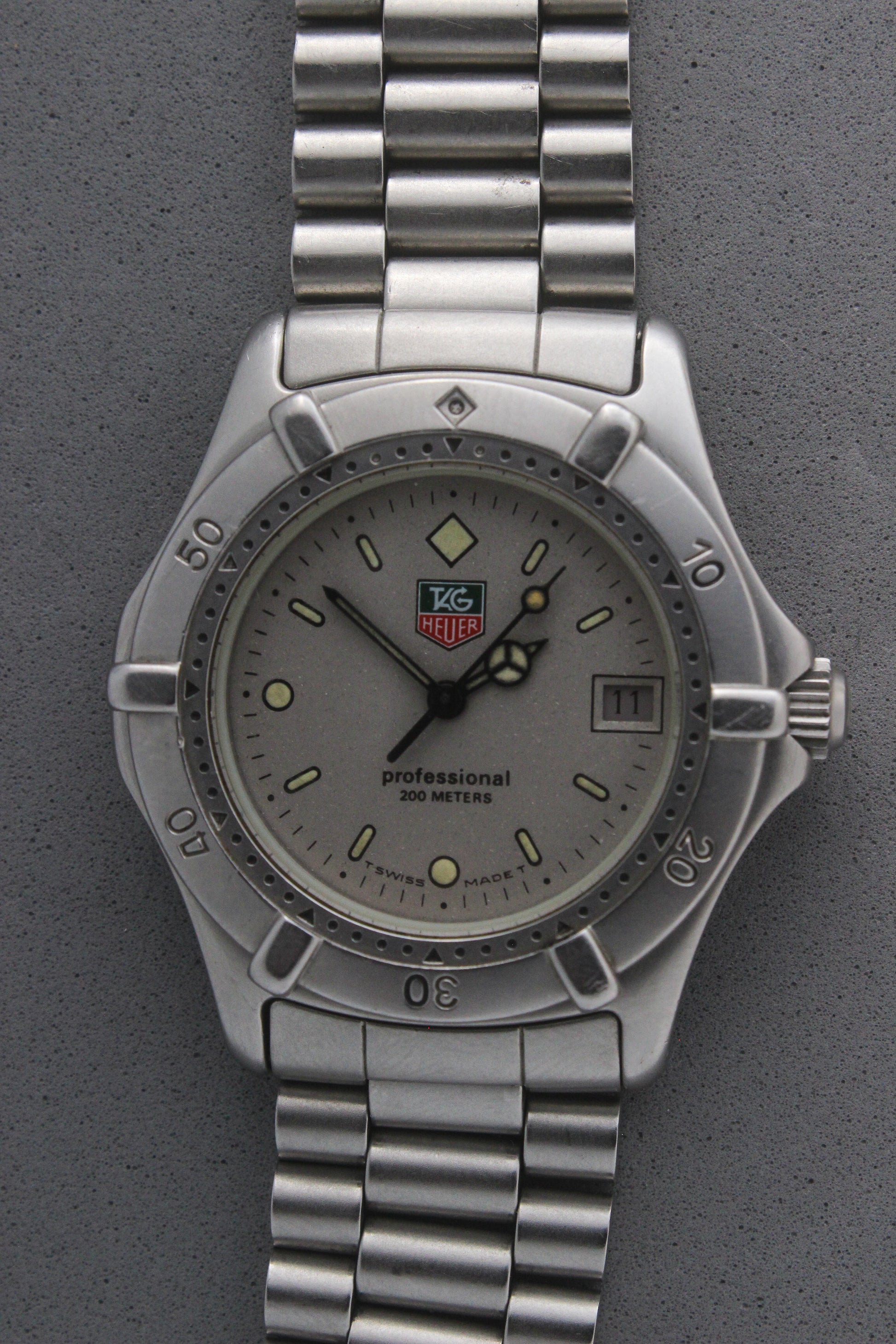 Close-up of the TAG Heuer Professional Ref.
962.213R case back showcasing engravings including "962.213R," "Water Resistant 200m
Tested," and "Swiss Made." The TAG Heuer logo and brushed stainless steel highlight the quality craftsmanship.