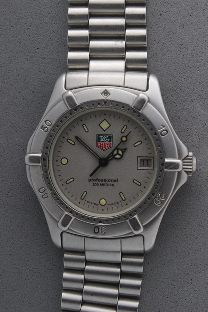 Close-up of the TAG Heuer Professional Ref.
962.213R case back showcasing engravings including "962.213R," "Water Resistant 200m
Tested," and "Swiss Made." The TAG Heuer logo and brushed stainless steel highlight the quality craftsmanship.