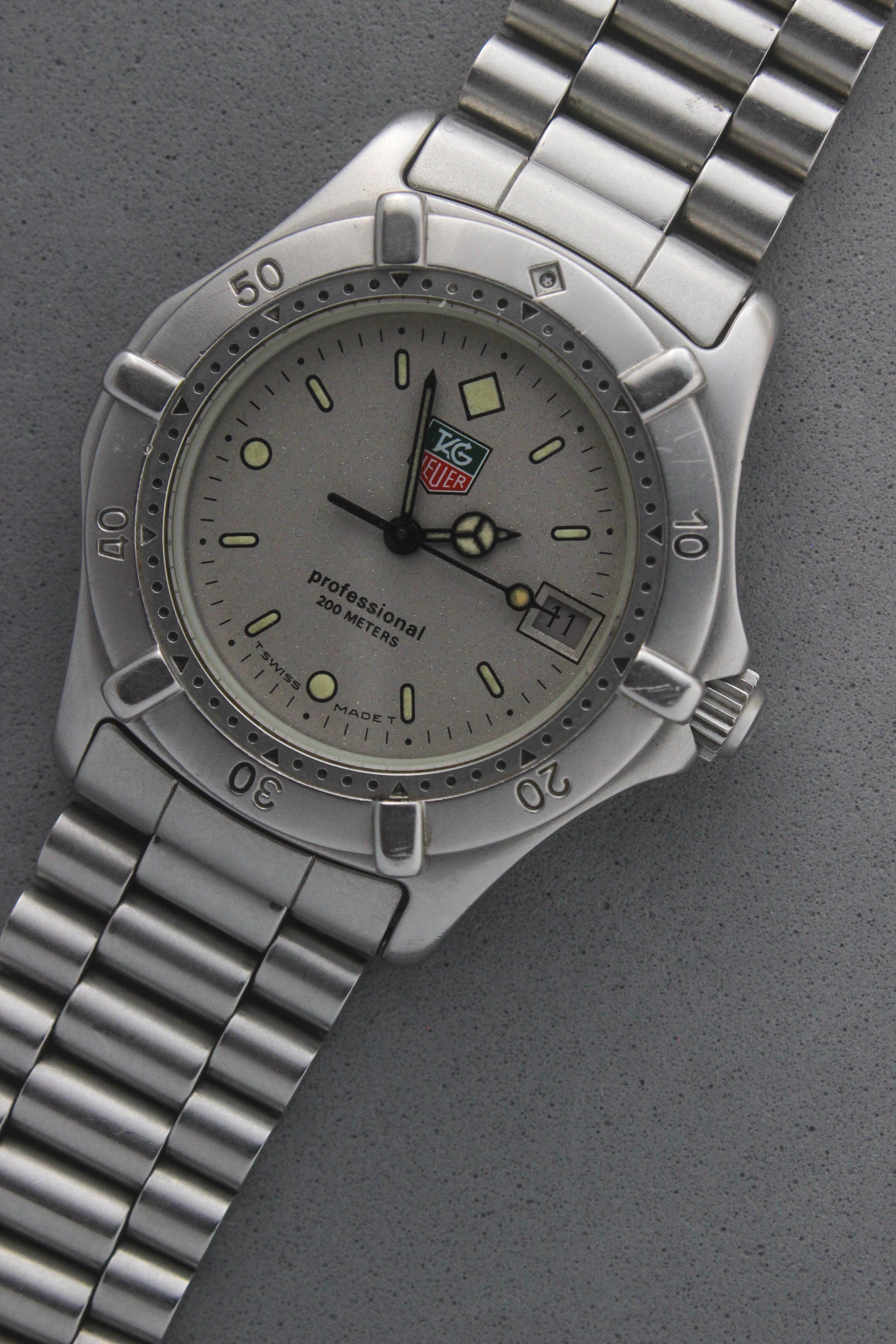 Close-up of the TAG Heuer Professional Ref.
962.213R case back showcasing engravings including "962.213R," "Water Resistant 200m
Tested," and "Swiss Made." The TAG Heuer logo and brushed stainless steel highlight the quality craftsmanship.