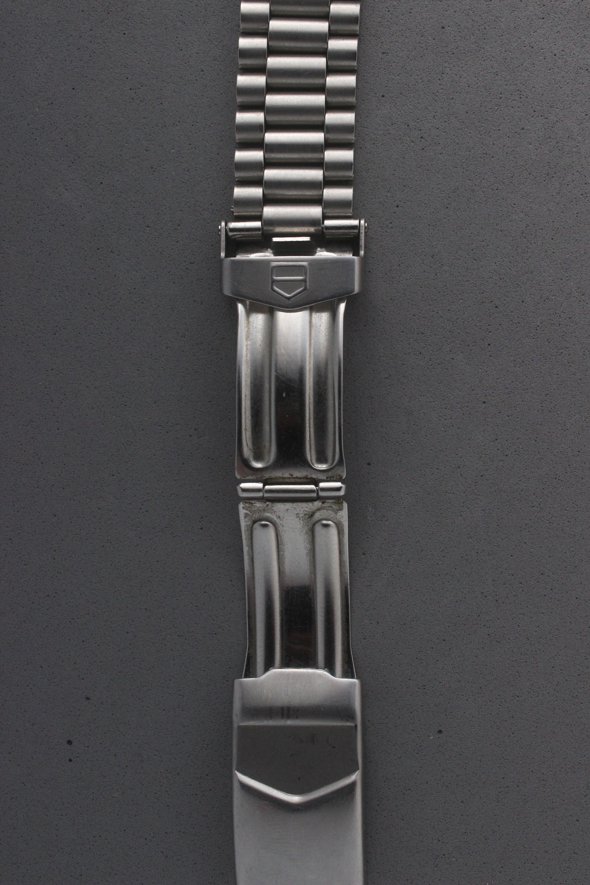 A close-up of the TAG Heuer Professional Ref. 962.213R bracelet clasp, featuring the engraved TAG Heuer shield logo and secure locking mechanism. The polished finish adds elegance and functionality.
