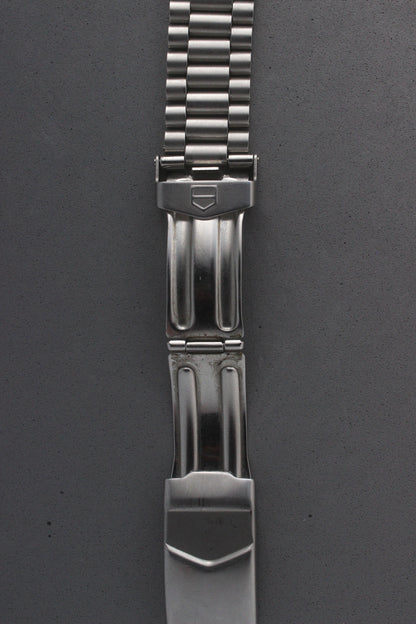A close-up of the TAG Heuer Professional Ref. 962.213R bracelet clasp, featuring the engraved TAG Heuer shield logo and secure locking mechanism. The polished finish adds elegance and functionality.

