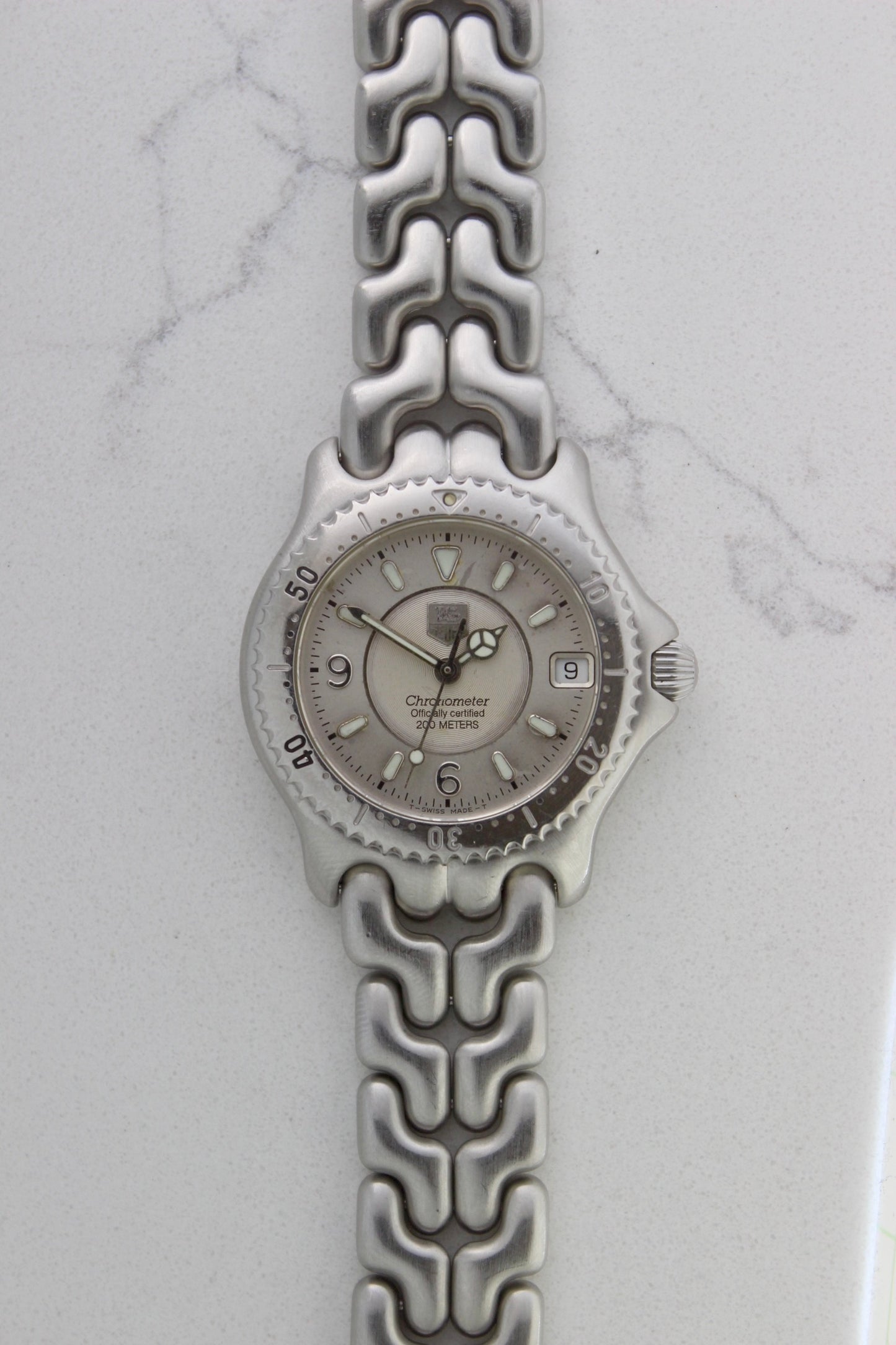 Tag Heuer S/EL Ref. WG5113-P0 stainless steel automatic chronometer watch, 35mm case, 8.6mm thick. Features a two-level dial, TAG Heuer logo, numerals at 6 & 9 o’clock, and a date window. Rotating steel diver bezel, original 6.9" bracelet, and 21-jewel self-winding movement. Includes dive bezel, hours, minutes, seconds & date functions. Rare configuration in great condition with minimal wear. 