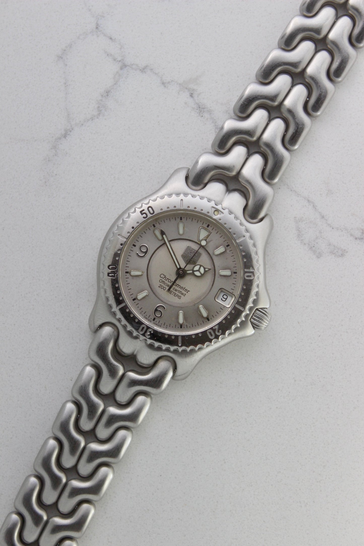 Tag Heuer S/EL Ref. WG5113-P0 stainless steel automatic chronometer watch, 35mm case, 8.6mm thick. Features a two-level dial, TAG Heuer logo, numerals at 6 & 9 o’clock, and a date window. Rotating steel diver bezel, original 6.9" bracelet, and 21-jewel self-winding movement. Includes dive bezel, hours, minutes, seconds & date functions. Rare configuration in great condition with minimal wear. 