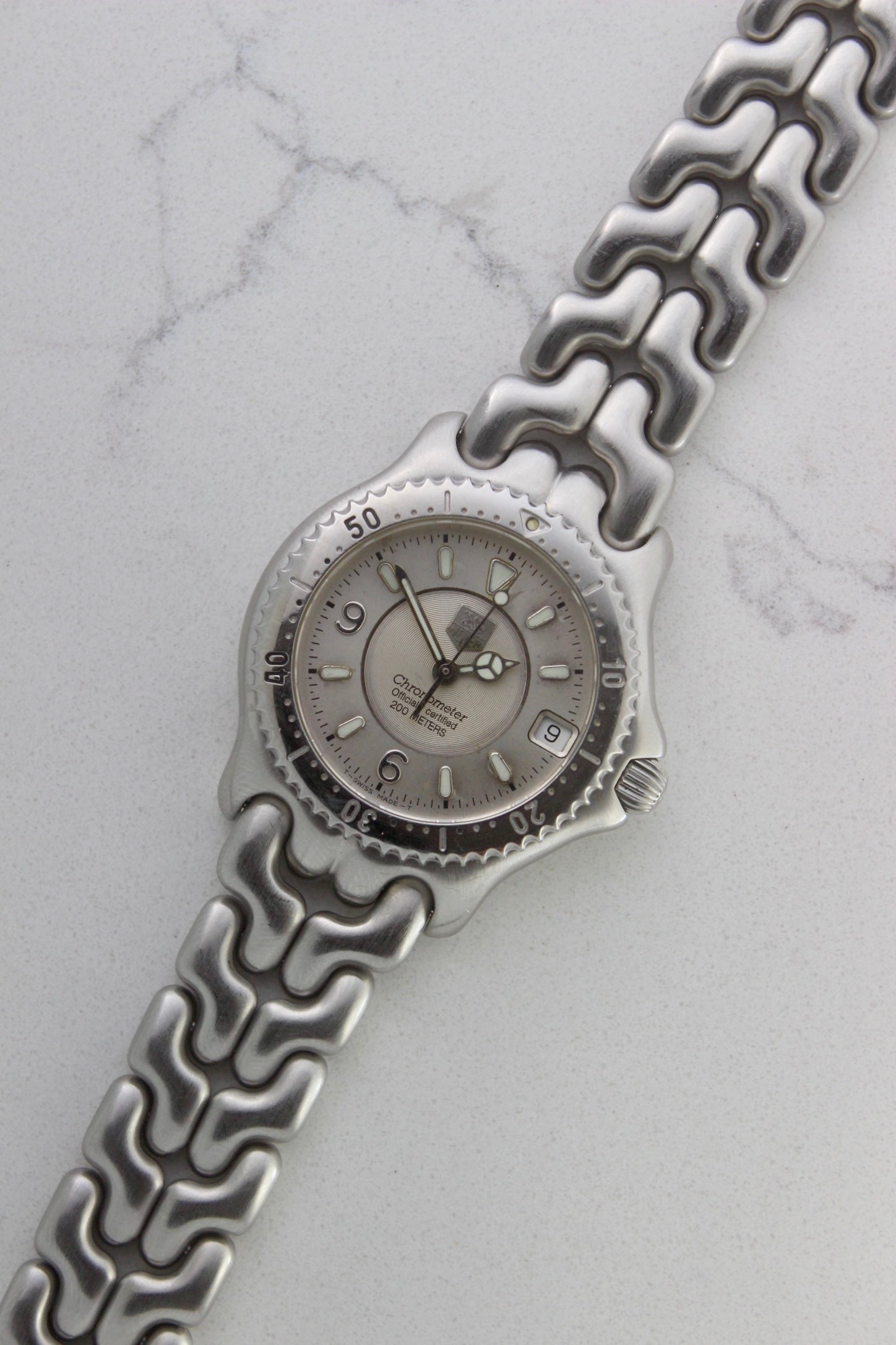 Tag Heuer S/EL Ref. WG5113-P0 stainless steel automatic chronometer watch, 35mm case, 8.6mm thick. Features a two-level dial, TAG Heuer logo, numerals at 6 & 9 o’clock, and a date window. Rotating steel diver bezel, original 6.9" bracelet, and 21-jewel self-winding movement. Includes dive bezel, hours, minutes, seconds & date functions. Rare configuration in great condition with minimal wear. 