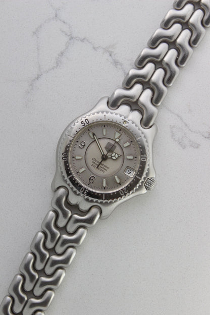 Tag Heuer S/EL Ref. WG5113-P0 stainless steel automatic chronometer watch, 35mm case, 8.6mm thick. Features a two-level dial, TAG Heuer logo, numerals at 6 & 9 o’clock, and a date window. Rotating steel diver bezel, original 6.9" bracelet, and 21-jewel self-winding movement. Includes dive bezel, hours, minutes, seconds & date functions. Rare configuration in great condition with minimal wear. 