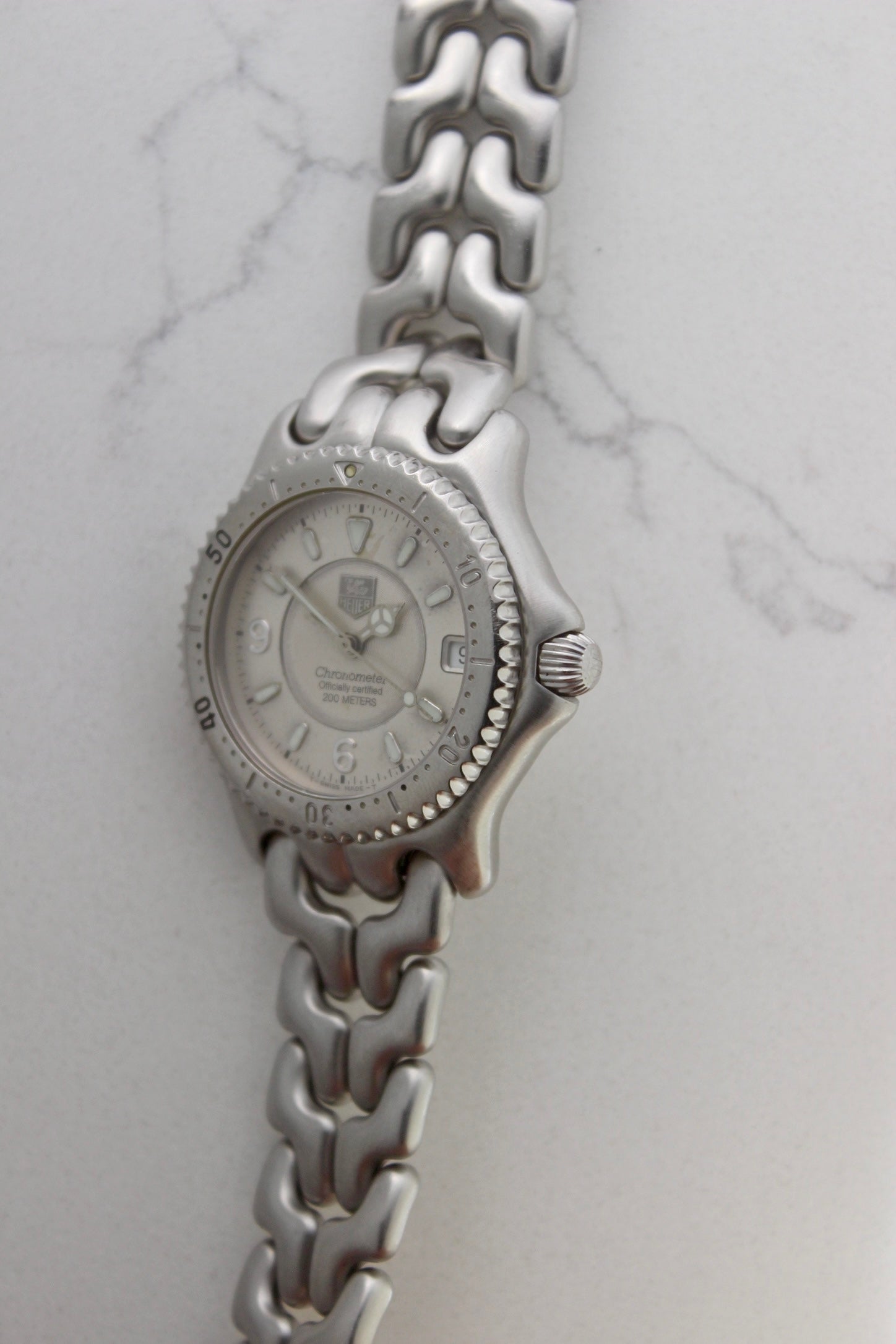Tag Heuer S/EL Ref. WG5113-P0 stainless steel automatic chronometer watch, 35mm case, 8.6mm thick. Features a two-level dial, TAG Heuer logo, numerals at 6 & 9 o’clock, and a date window. Rotating steel diver bezel, original 6.9" bracelet, and 21-jewel self-winding movement. Includes dive bezel, hours, minutes, seconds & date functions. Rare configuration in great condition with minimal wear. 