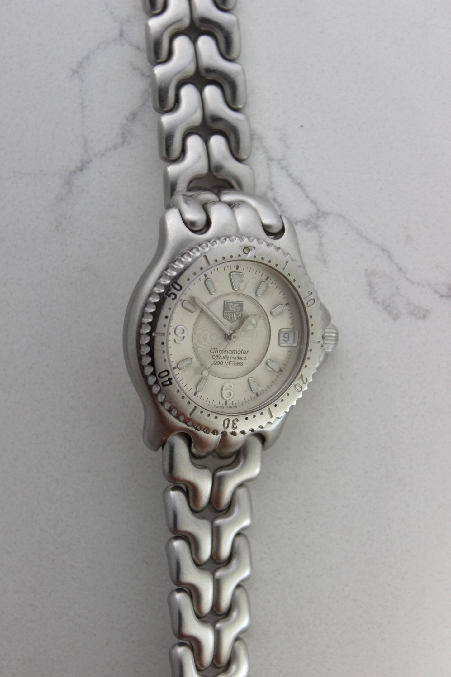 Tag Heuer S/EL Ref. WG5113-P0 stainless steel automatic chronometer watch, 35mm case, 8.6mm thick. Features a two-level dial, TAG Heuer logo, numerals at 6 & 9 o’clock, and a date window. Rotating steel diver bezel, original 6.9" bracelet, and 21-jewel self-winding movement. Includes dive bezel, hours, minutes, seconds & date functions. Rare configuration in great condition with minimal wear. 