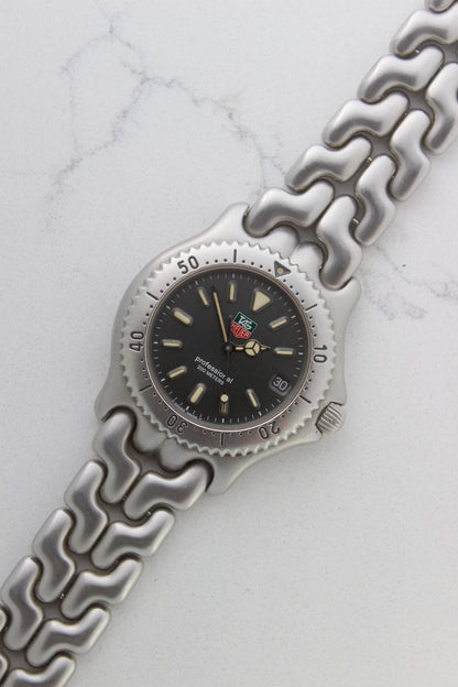 Tag Heuer Professional S/EL Ref. S99.206 stainless steel quartz dive watch with a 39mm case, volcanic grey dial, luminous markers, and rotating diver bezel. Features an original 7" bracelet, date window at 3 o’clock, and durable sapphire crystal. A rare vintage timepiece in excellent condition, perfect for collectors and enthusiasts.