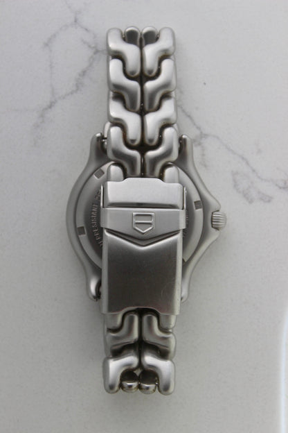 Tag Heuer S/EL Professional watch clasp, featuring the iconic stainless steel bracelet with a secure fold-over clasp engraved with the Tag Heuer shield logo. A durable and stylish vintage timepiece component.