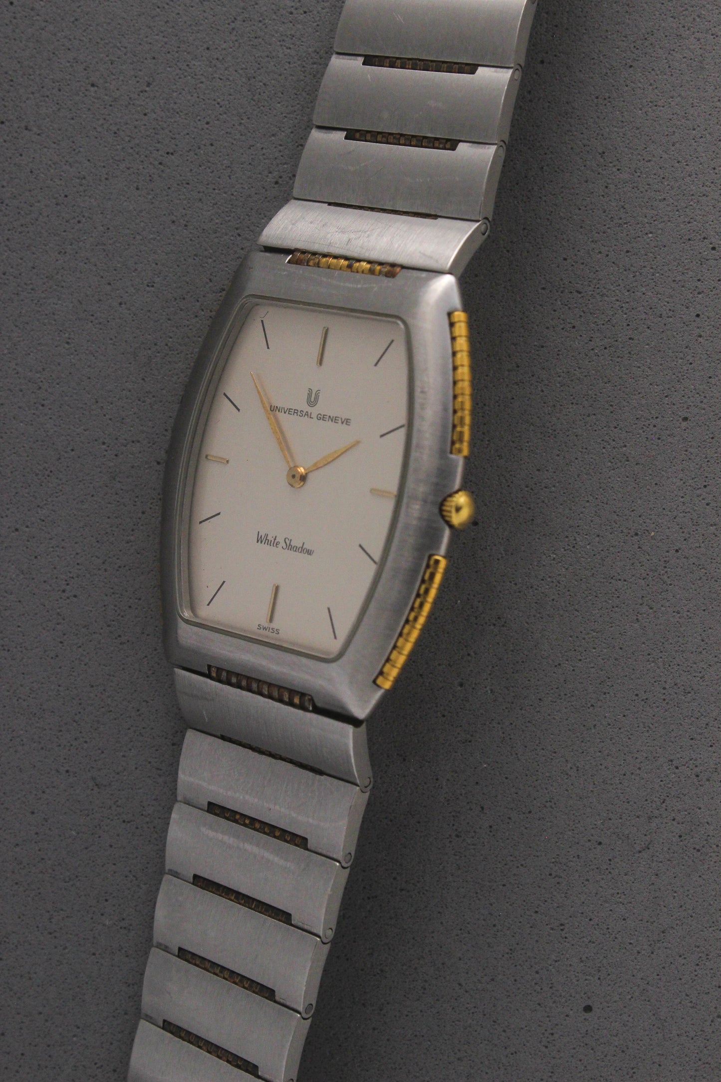 Front View of Universal Genève White Shadow Ref. 617-020
A close-up of the Universal Genève White Shadow Ref. 617-020, featuring a sleek tonneau-shaped stainless steel case with gold accents, a clean white dial, and minimalist stick hands and indices. Paired with an integrated stainless steel bracelet for timeless elegance.