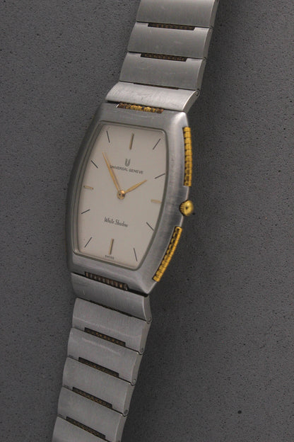 Front View of Universal Genève White Shadow Ref. 617-020
A close-up of the Universal Genève White Shadow Ref. 617-020, featuring a sleek tonneau-shaped stainless steel case with gold accents, a clean white dial, and minimalist stick hands and indices. Paired with an integrated stainless steel bracelet for timeless elegance.