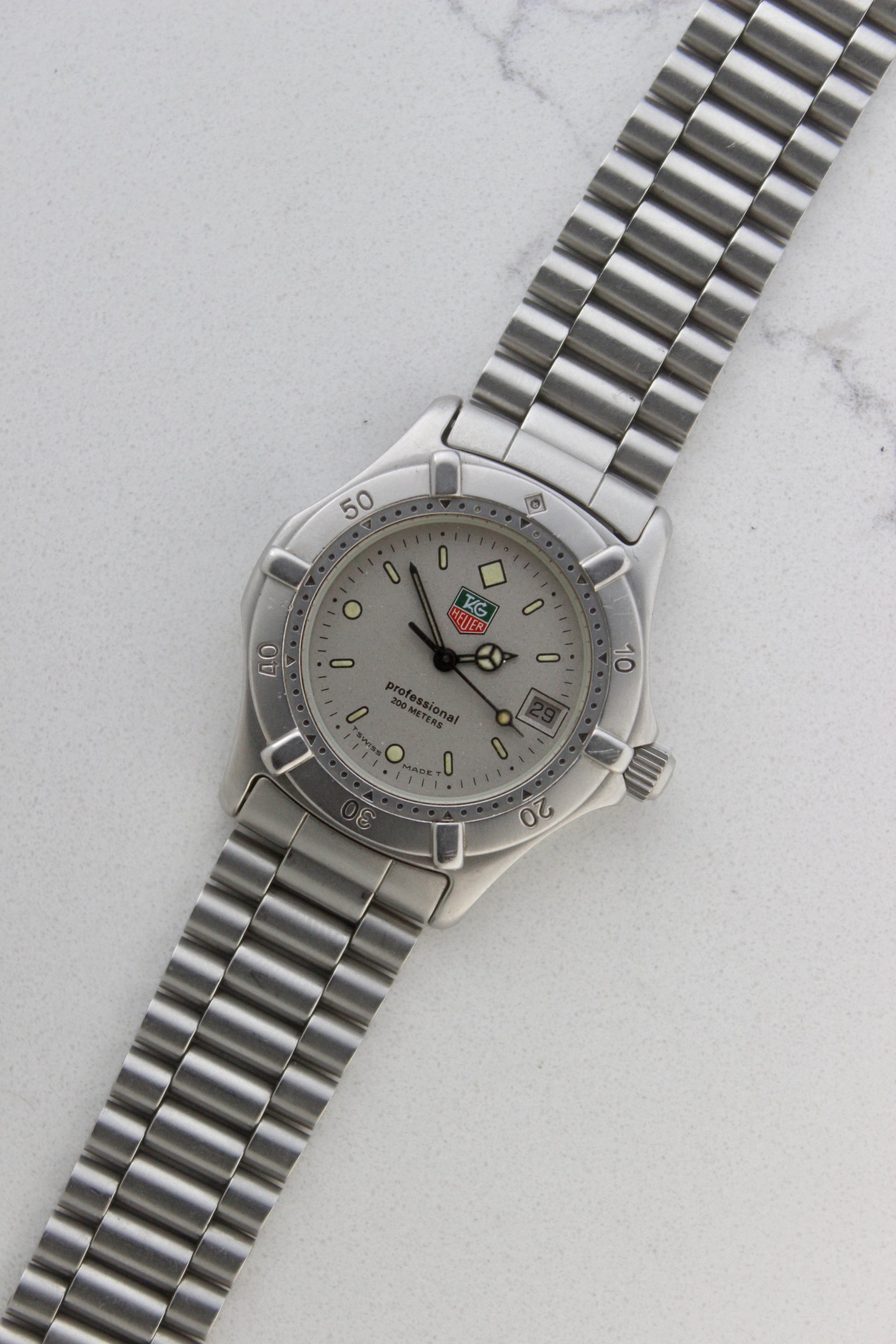 Close-up of the TAG Heuer Professional Ref.
962.213R case back showcasing engravings including "962.213R," "Water Resistant 200m
Tested," and "Swiss Made." The TAG Heuer logo and brushed stainless steel highlight the quality craftsmanship.