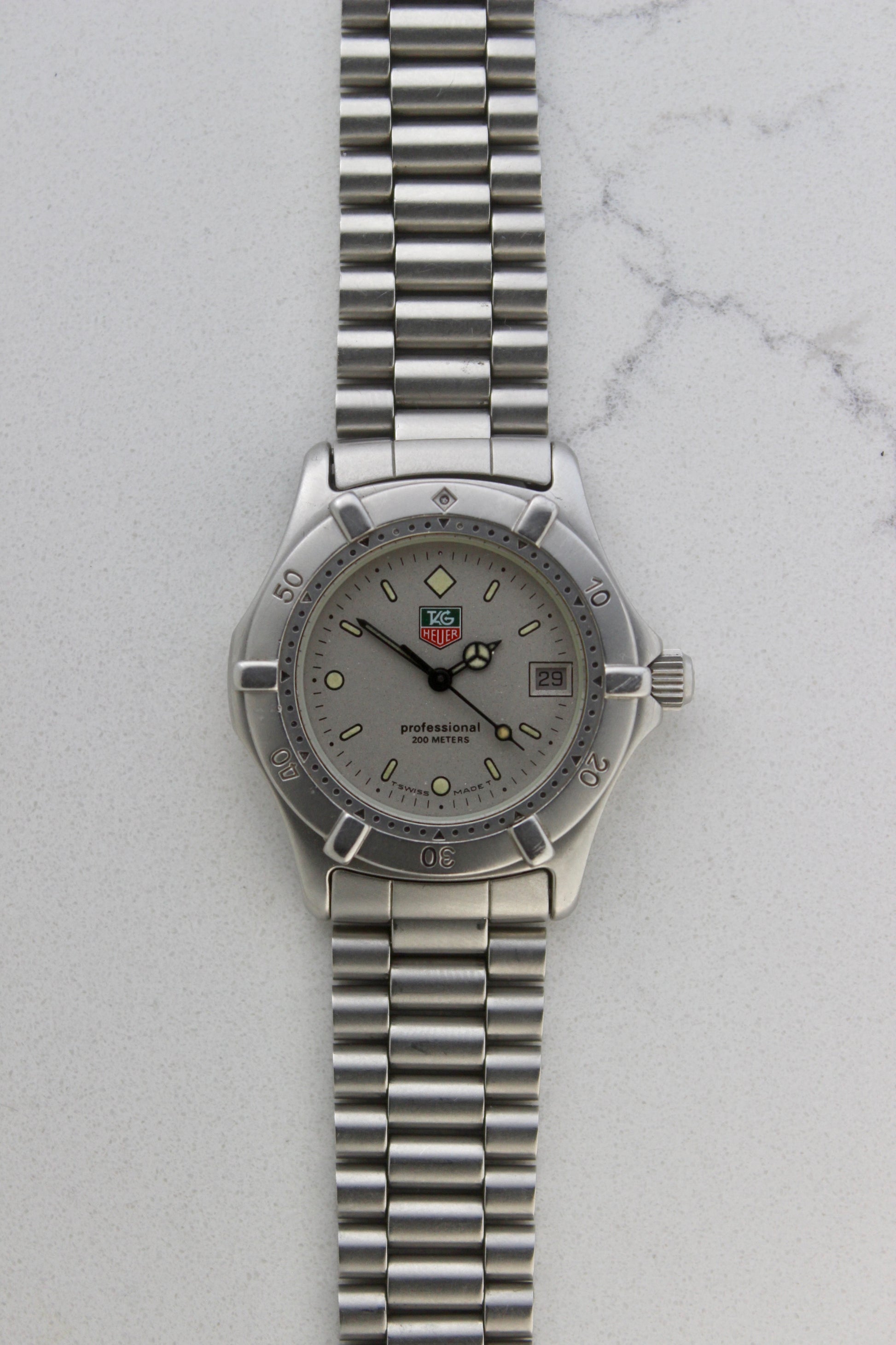 Close-up of the TAG Heuer Professional Ref.
962.213R case back showcasing engravings including "962.213R," "Water Resistant 200m
Tested," and "Swiss Made." The TAG Heuer logo and brushed stainless steel highlight the quality craftsmanship.
